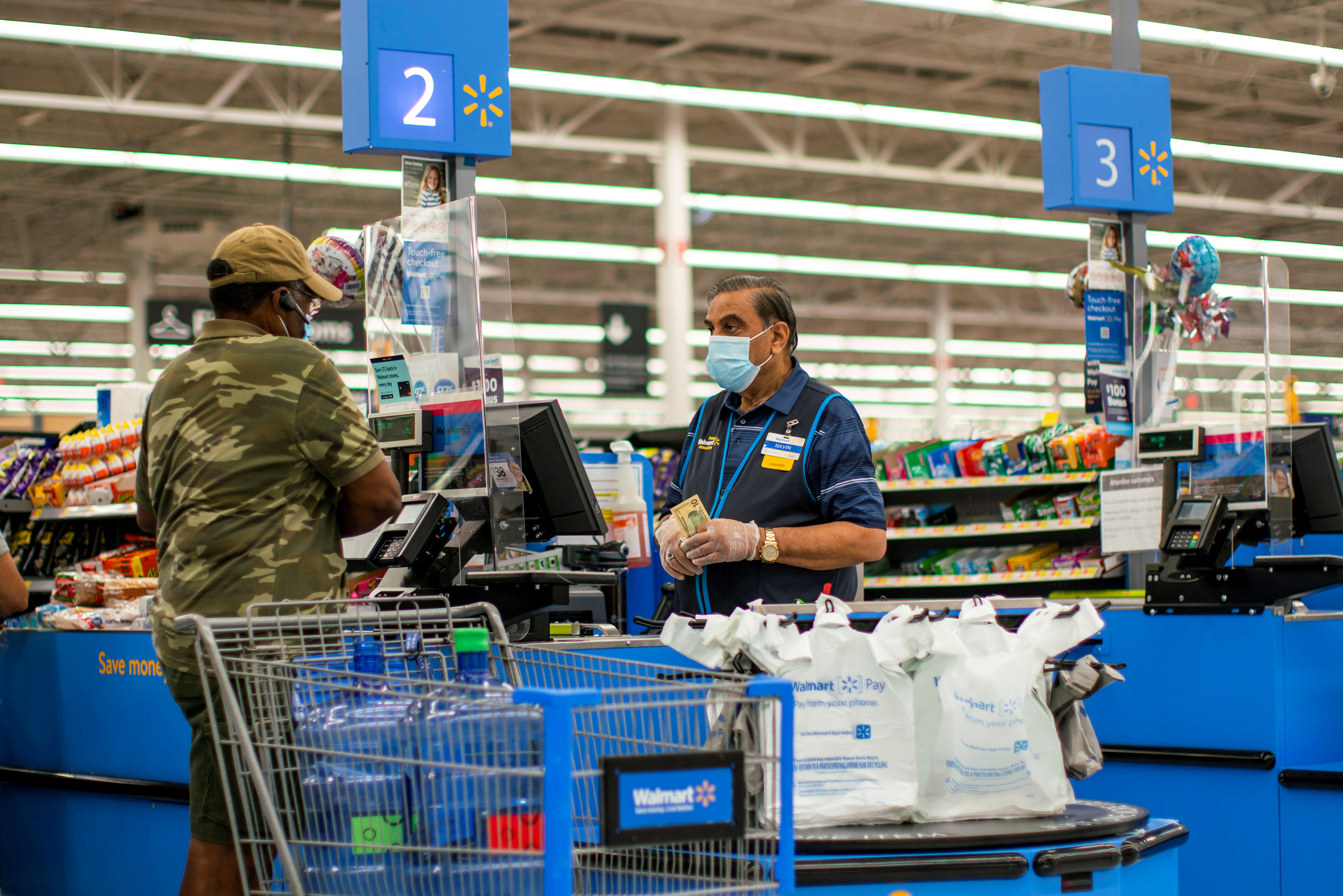 FILE PHOTO: A worker and a shopper are seen wearing masks at a Walmart store, in North Brunswick, New Jersey