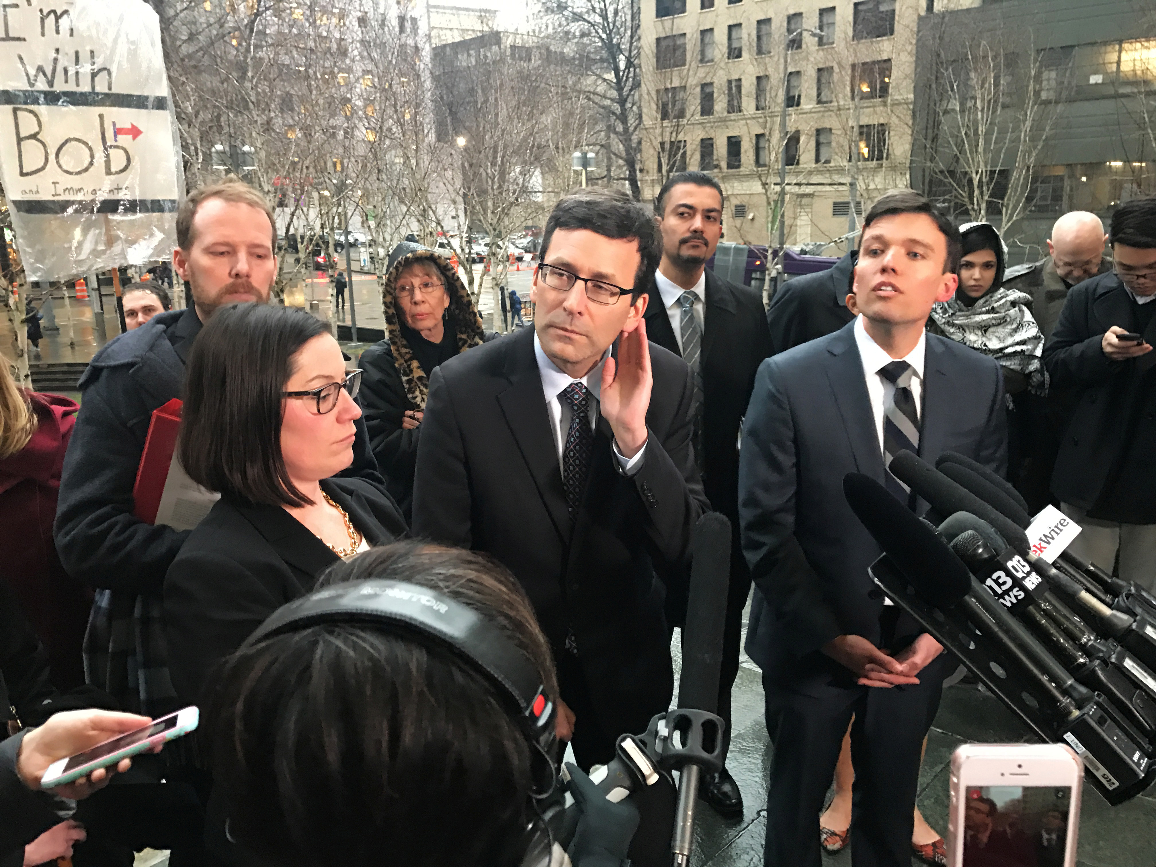 Washington state's attorney general Bob Ferguson (C) speaks to the media next to Washington state solicitor general Noah Purcell (R) outside the U.S. federal courthouse in downtown Seattle