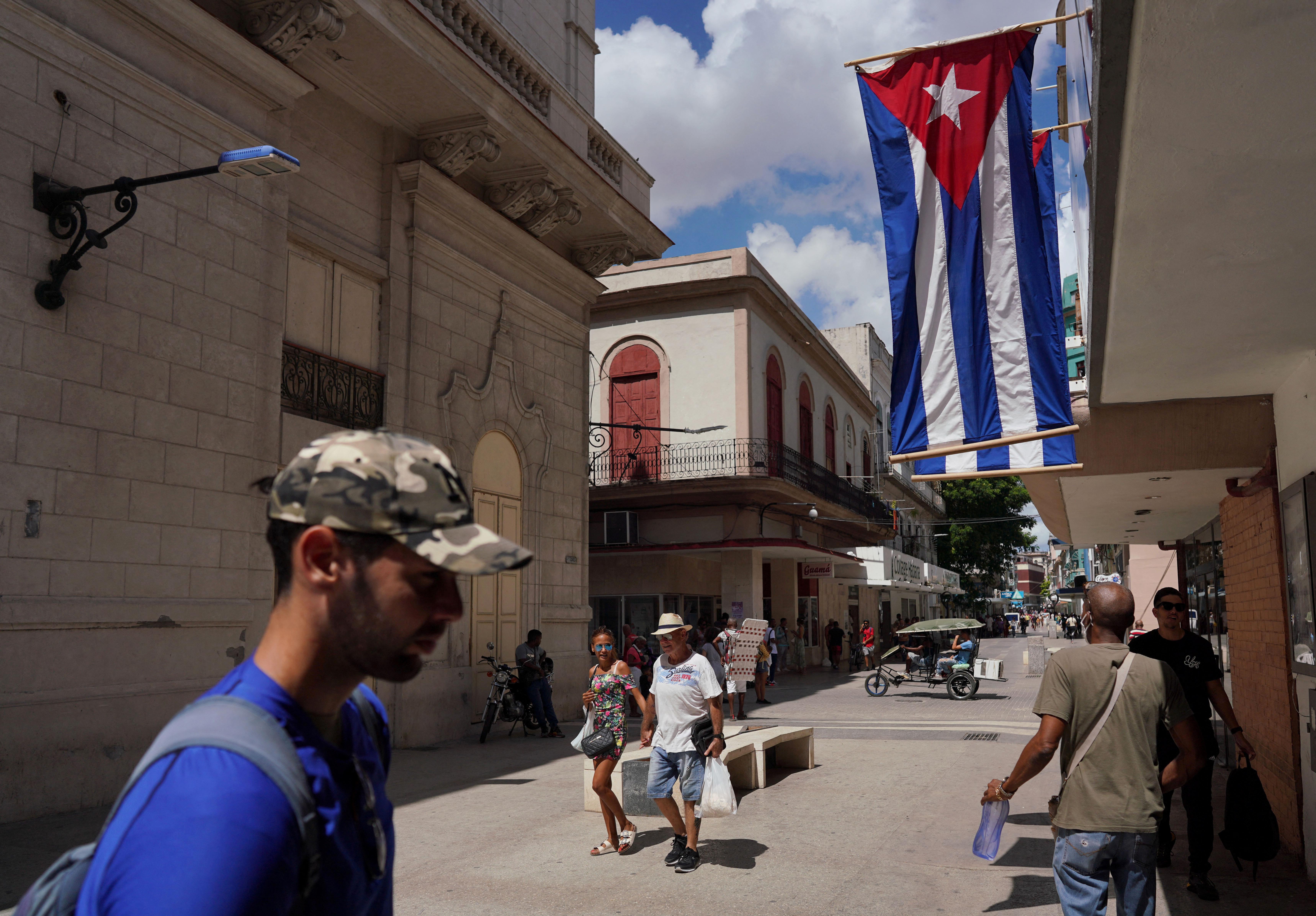 Cuban flags are displayed at a commercial road in Havana