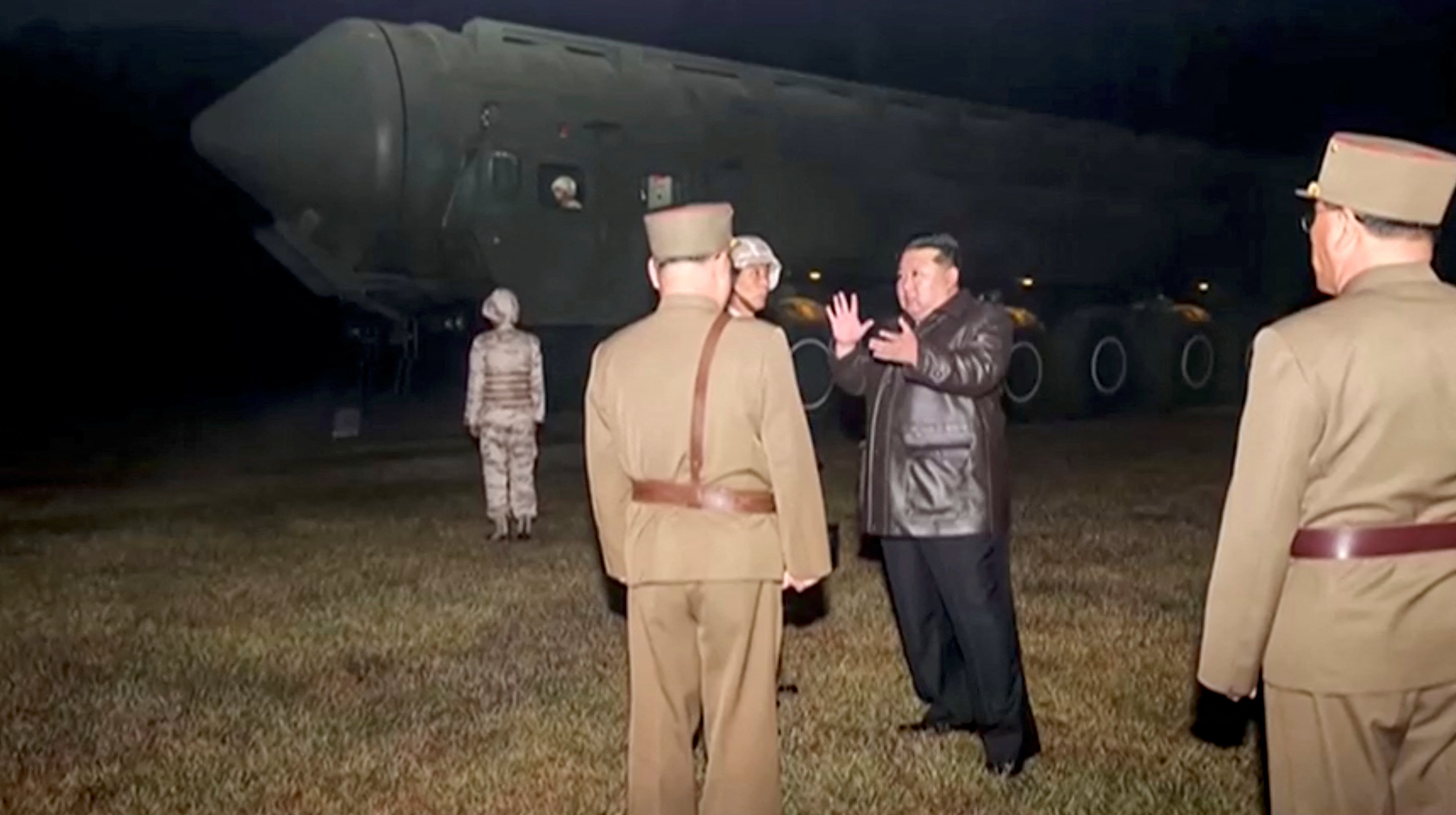 North Korean leader Kim Jong Un and military officials stand next to what they say is a mobile missile launcher vehicle at an undisclosed location in this undated still image used in a video released on November 1, 2024. KRT/via Reuters TV/Handout via REUTERS