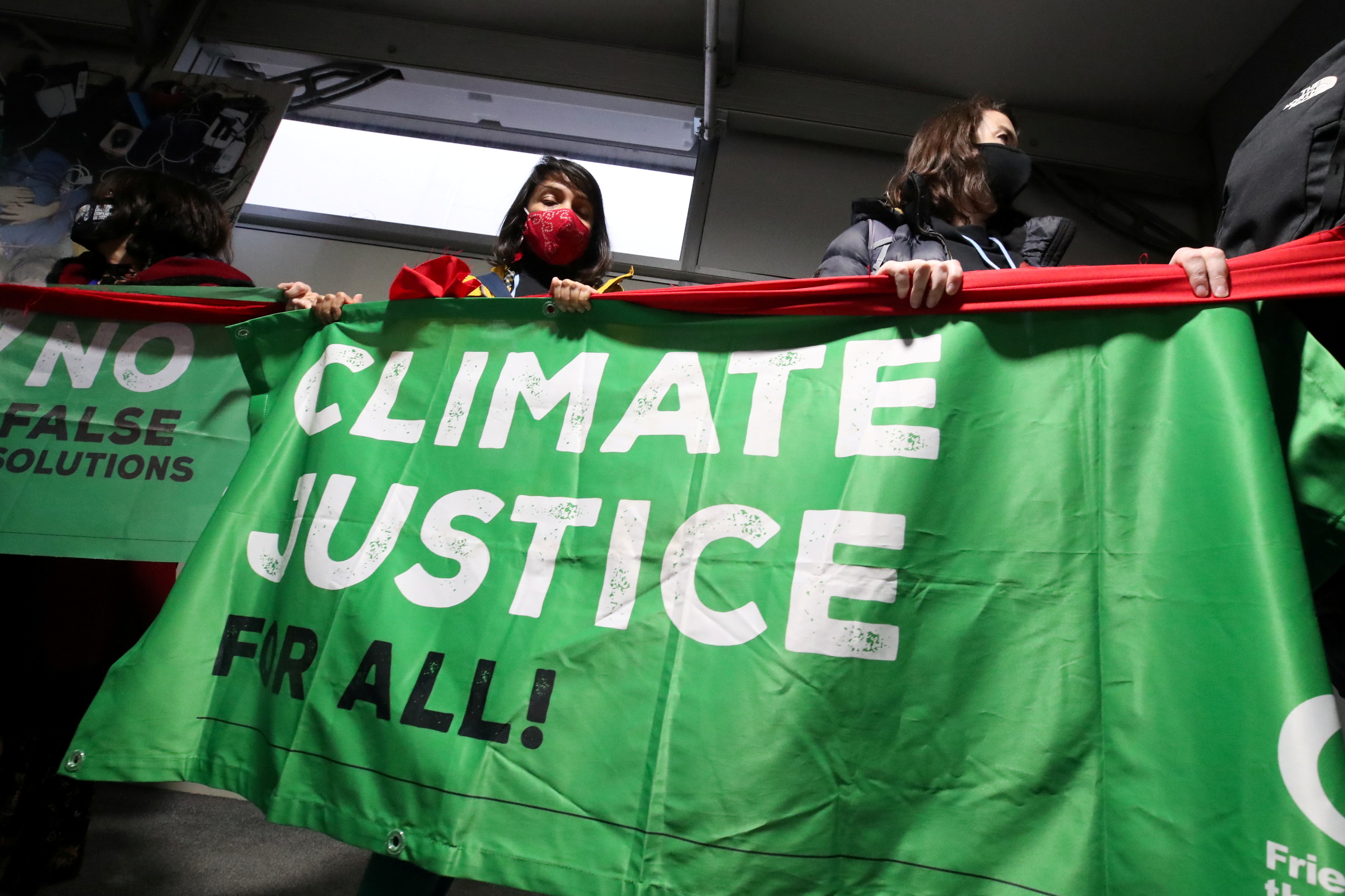 People hold a banner during a protest at the UN Climate Change Conference (COP26), in Glasgow, Scotland, Britain November 12, 2021. REUTERS/Yves Herman