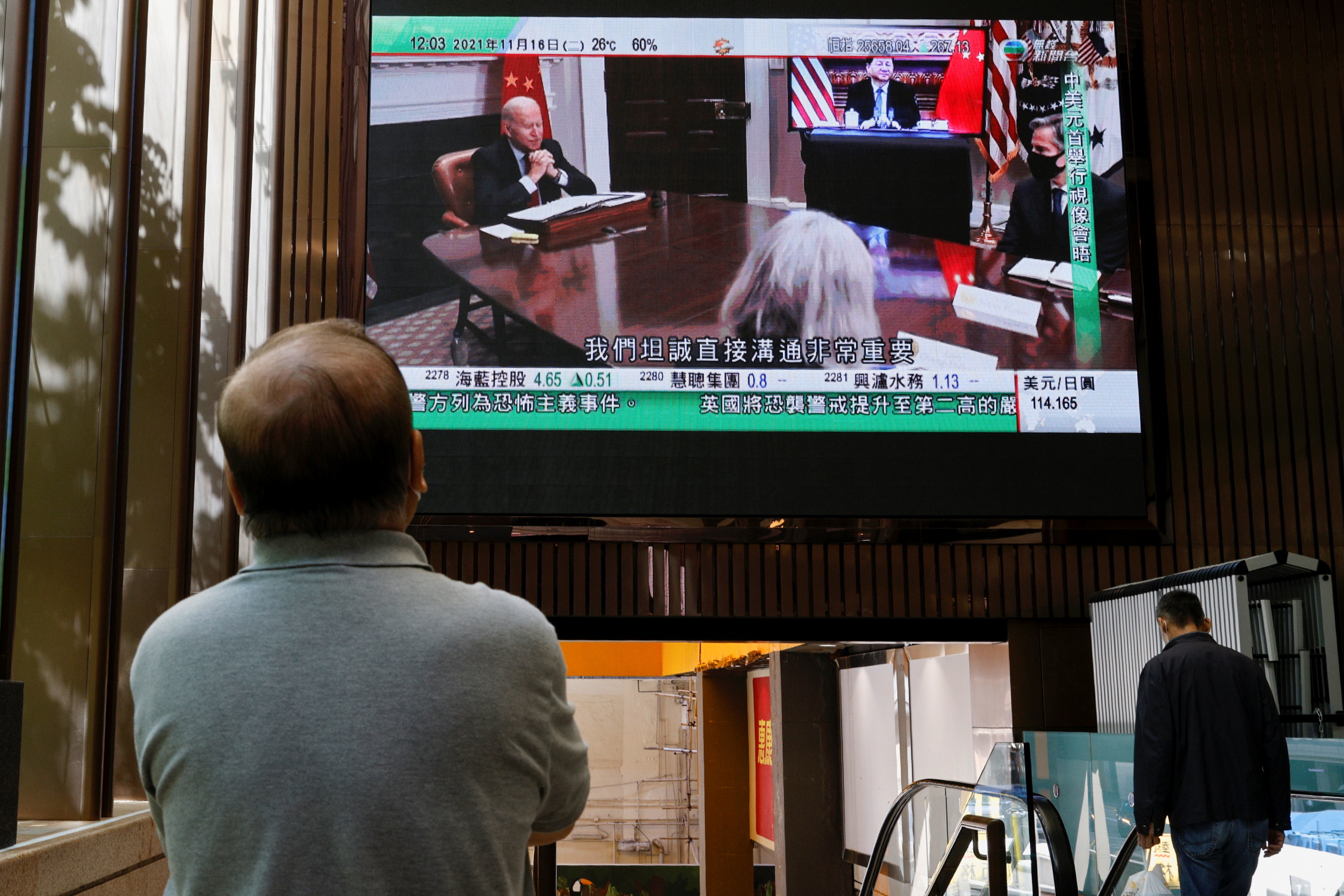 A TV screen shows news of a video meeting between U.S. President Joe Biden and Chinese President Xi Jinping, in Hong Kong
