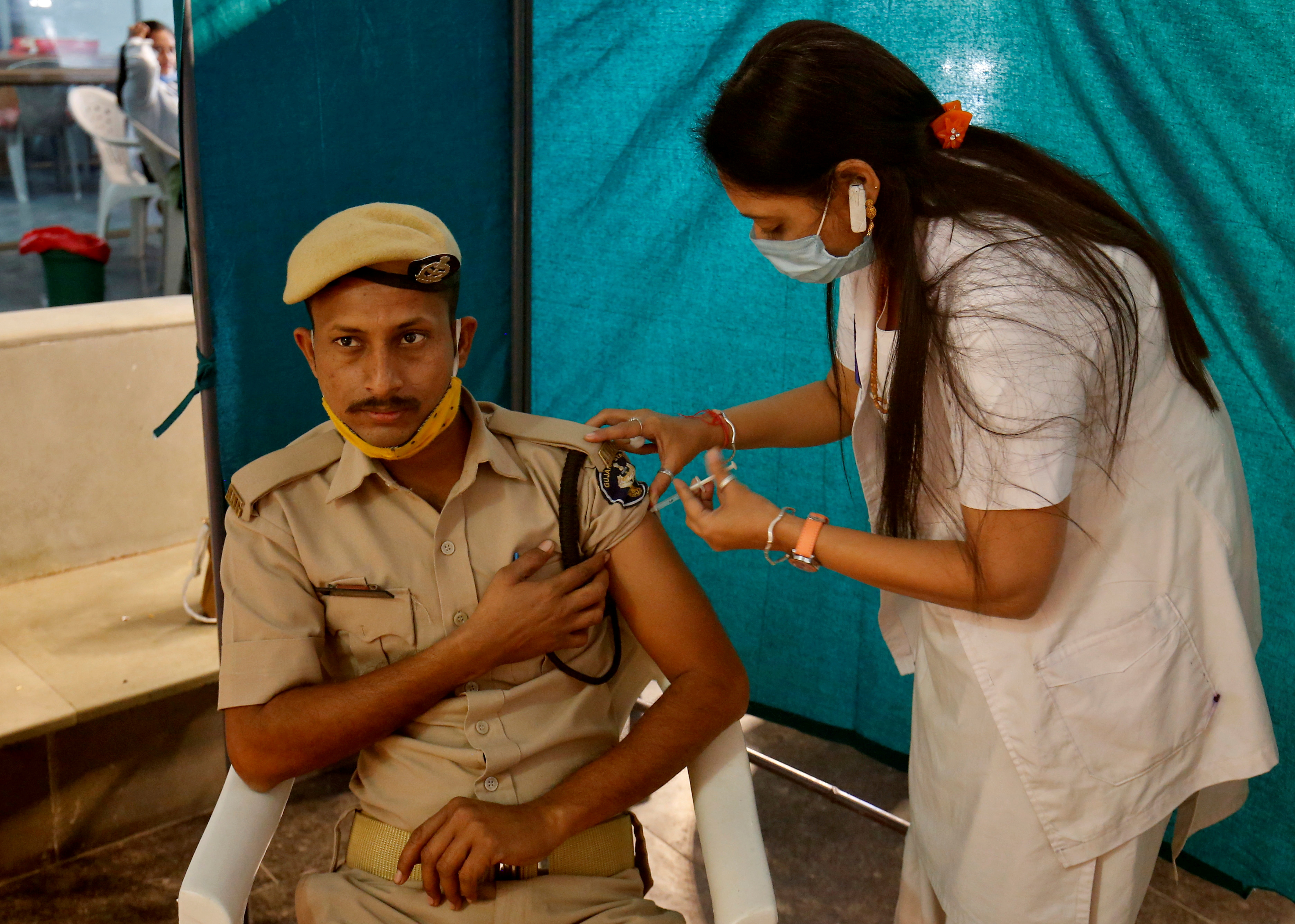 A policeman receives a dose of COVISHIELD, a COVID-19 vaccine manufactured by Serum Institute of India, at a vaccination centre in Ahmedabad, India, February 4, 2021. REUTERS/Amit Dave/File Photo