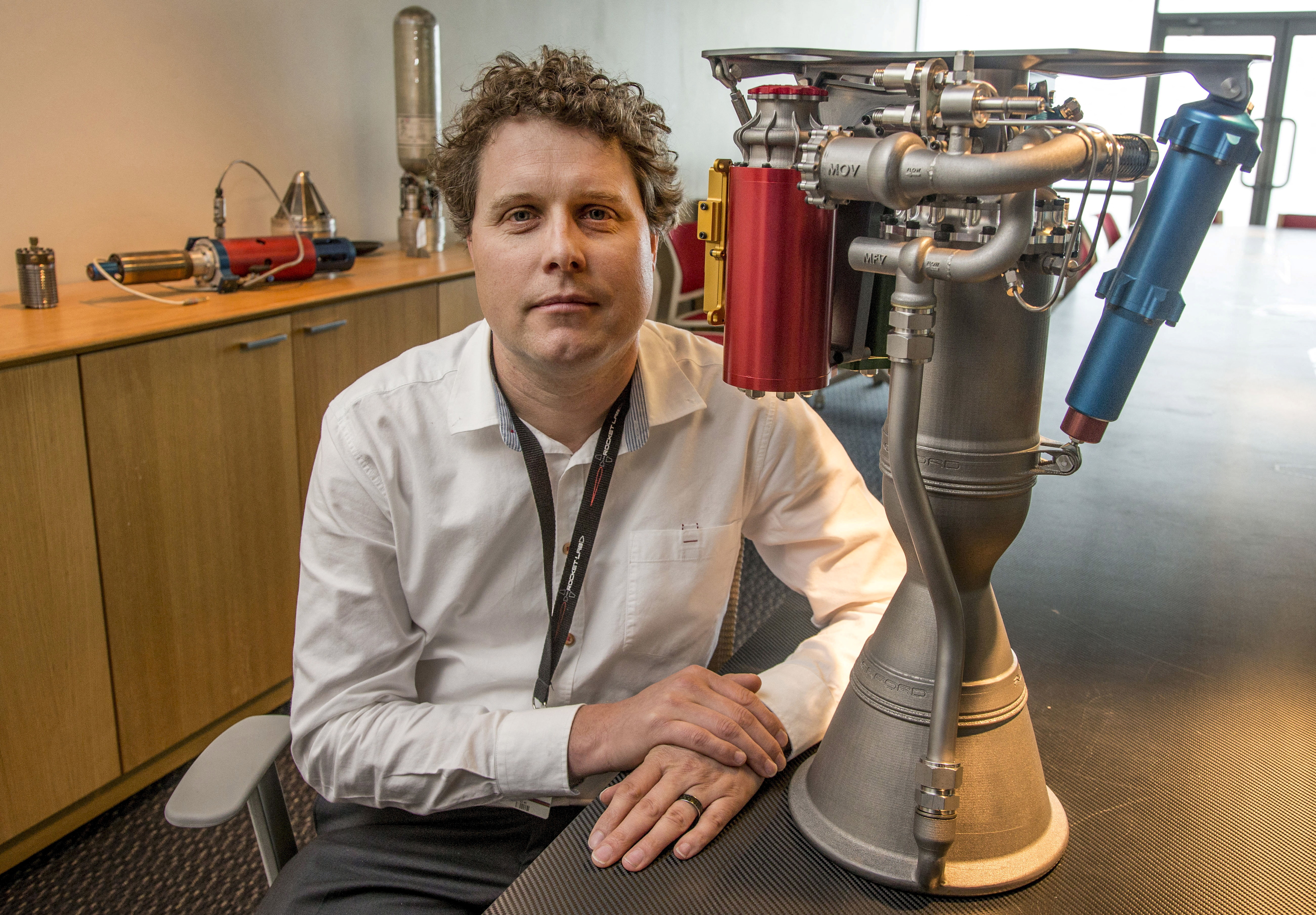 Rocket Lab CEO Peter Beck speaks alongside a Rutherford rocket engine in Auckland