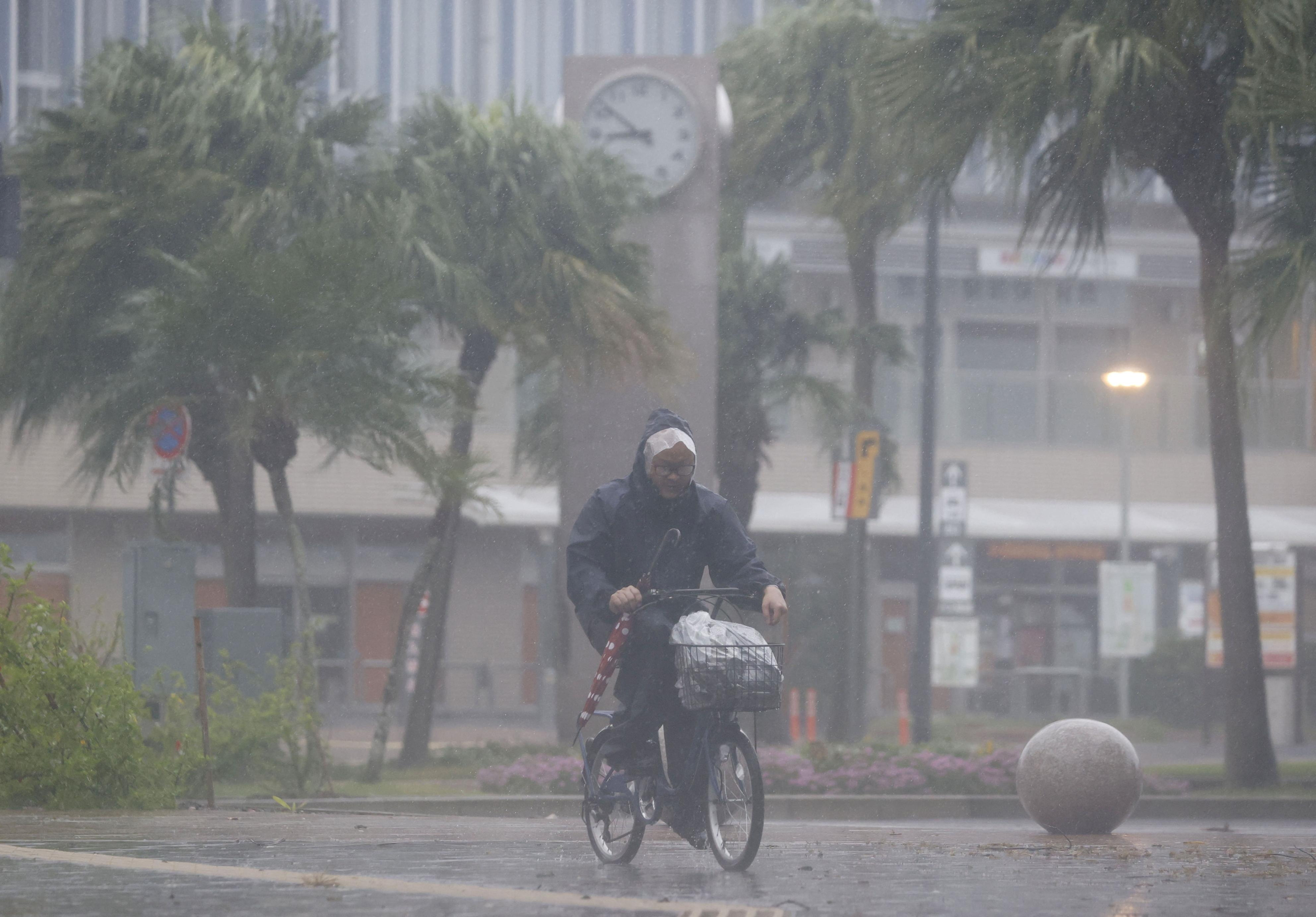 A man on a bicycle rides past in the heavy rain and wind caused by Typhoon Nanmadol in Miyazaki