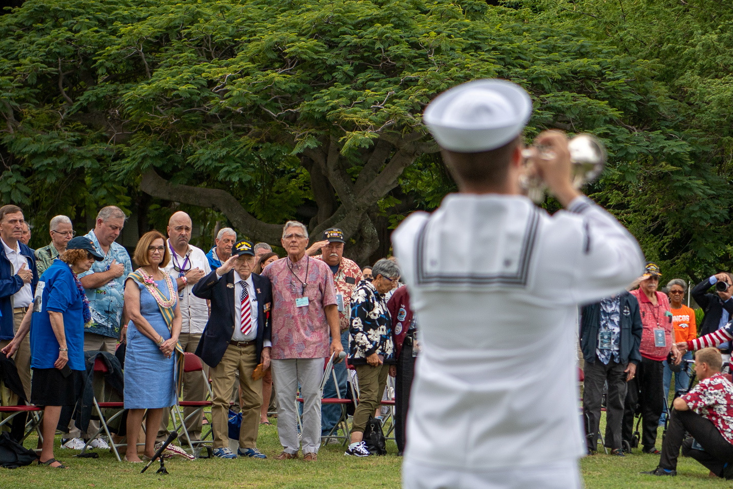 World War II veterans, along with families and friends, stand as 