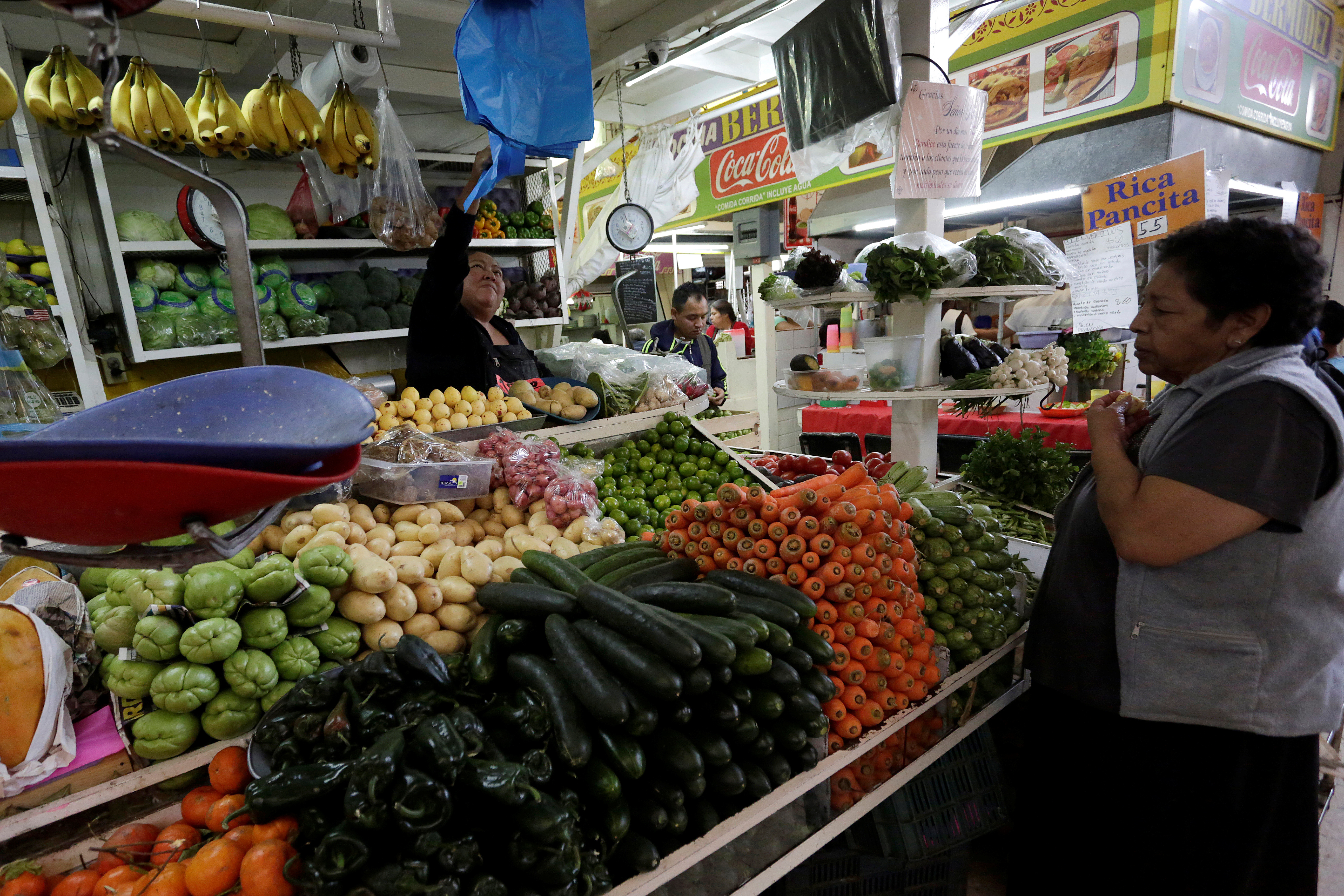 Woman buys vegetables at a market stall in Mexico City