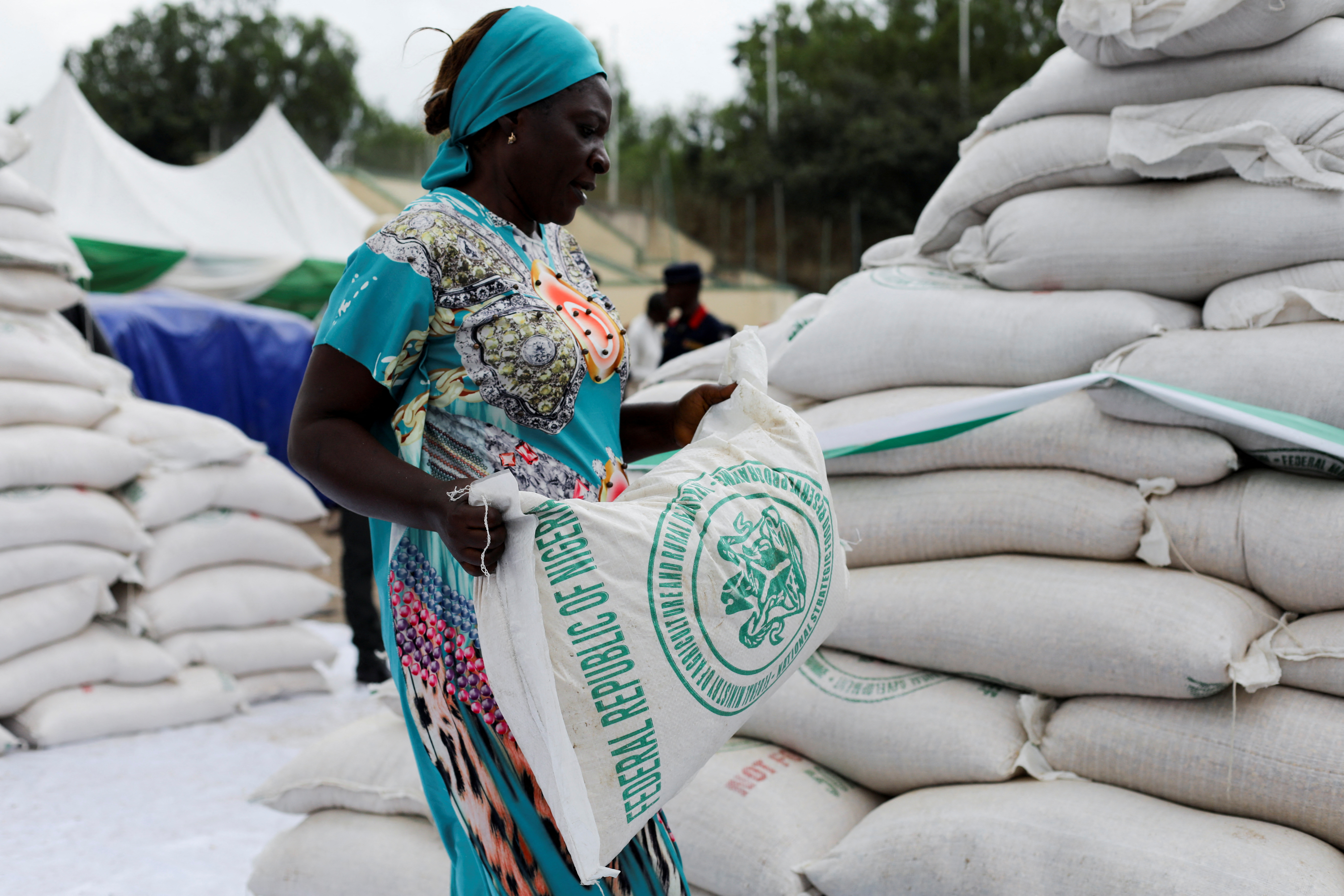 A woman receives a bag of food from the government during the distribution of food items by the government to cushion the high cost of living in Abuja