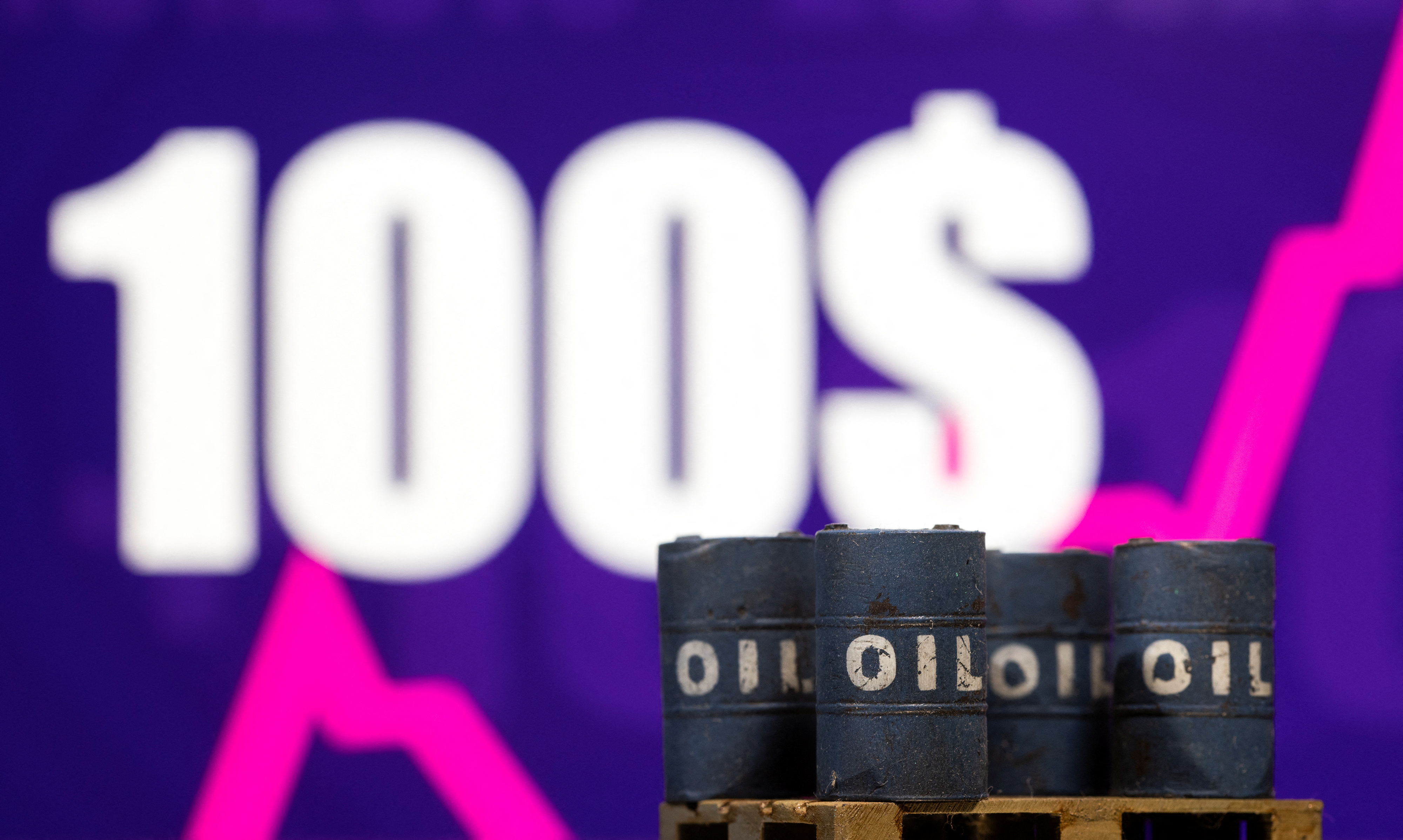 Illustration shows models of oil barrel in front of displayed rising stock graph