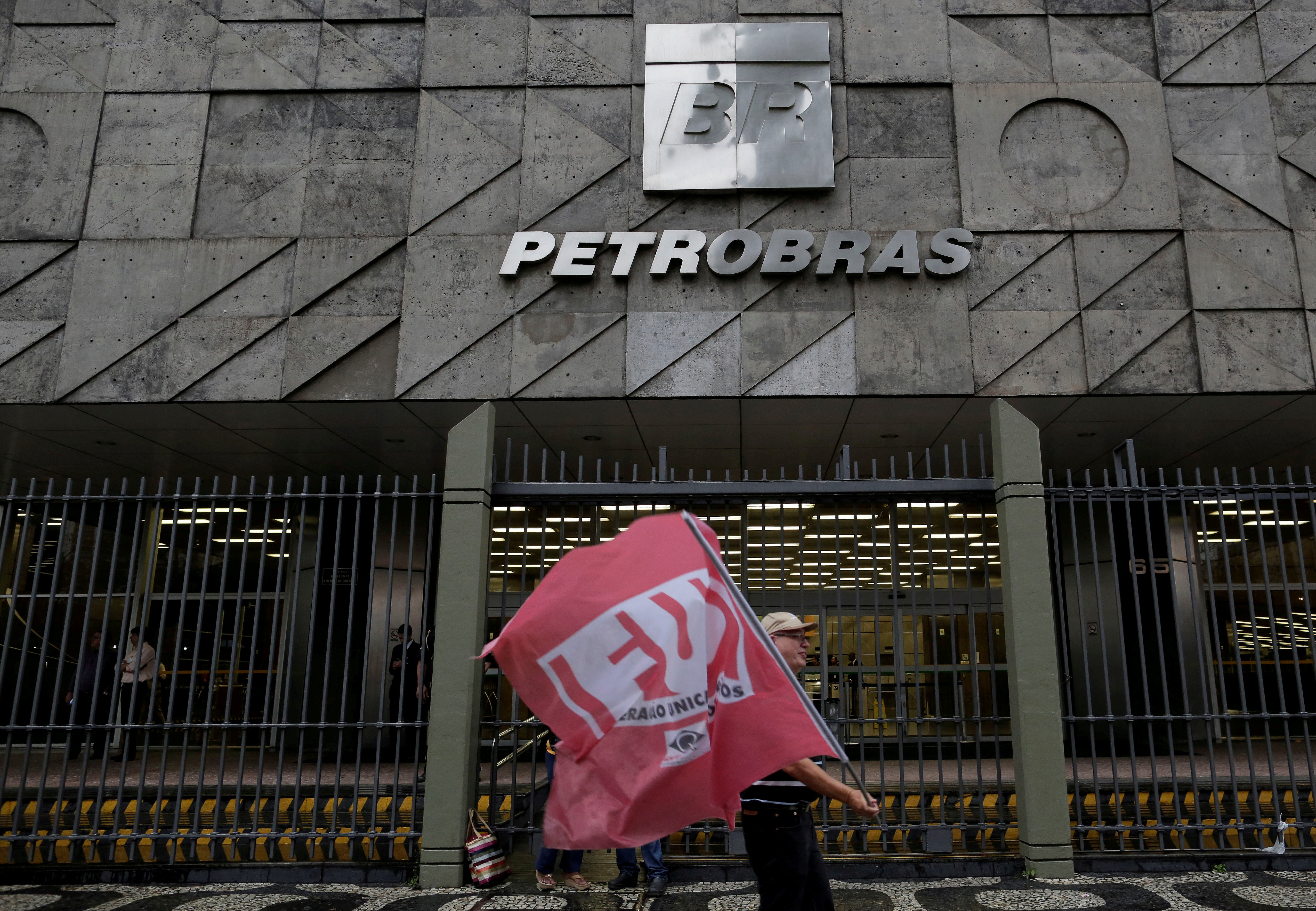 A man walks in front the headquarters of Brazil's state-run Petrobras oil company, during a protest against the privatisation of state owned companies in Rio de Janeiro