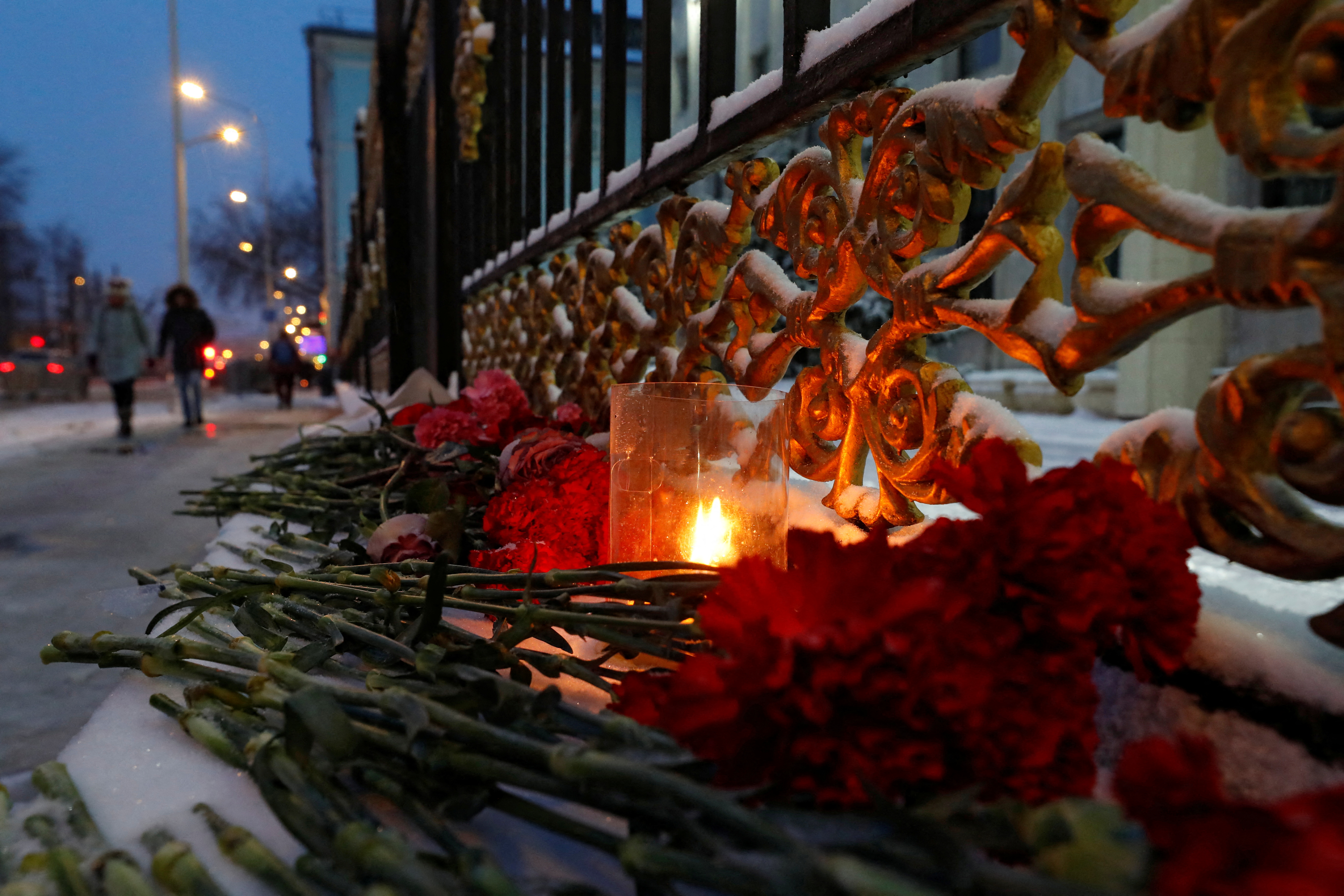 A candle and flowers are placed outside the Kazakh Embassy in Moscow