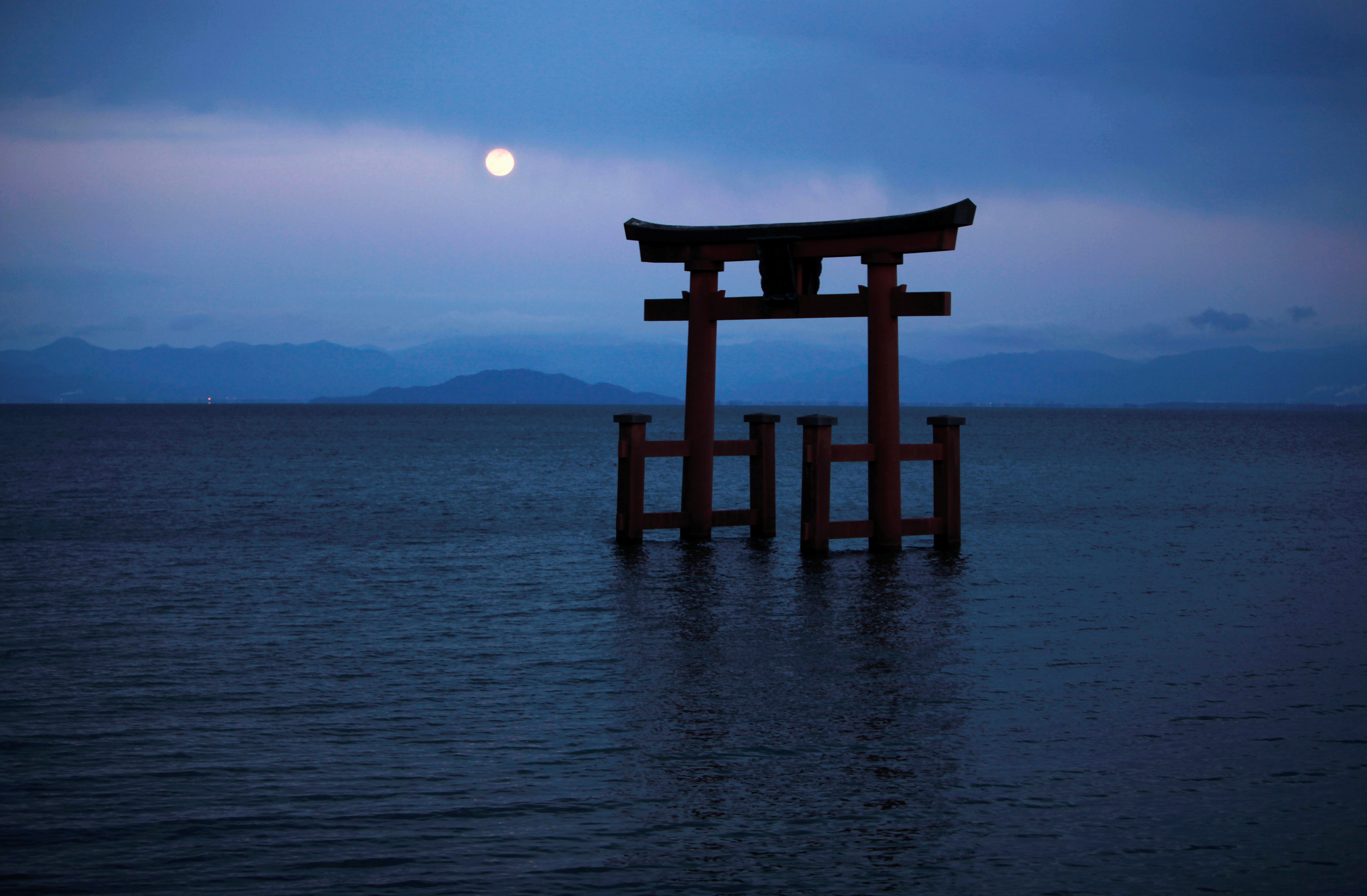A Shinto shrine gate, with the moon behind it, is seen amidst Japan's largest lake, Lake Biwa, in Takashima, Shiga prefecture