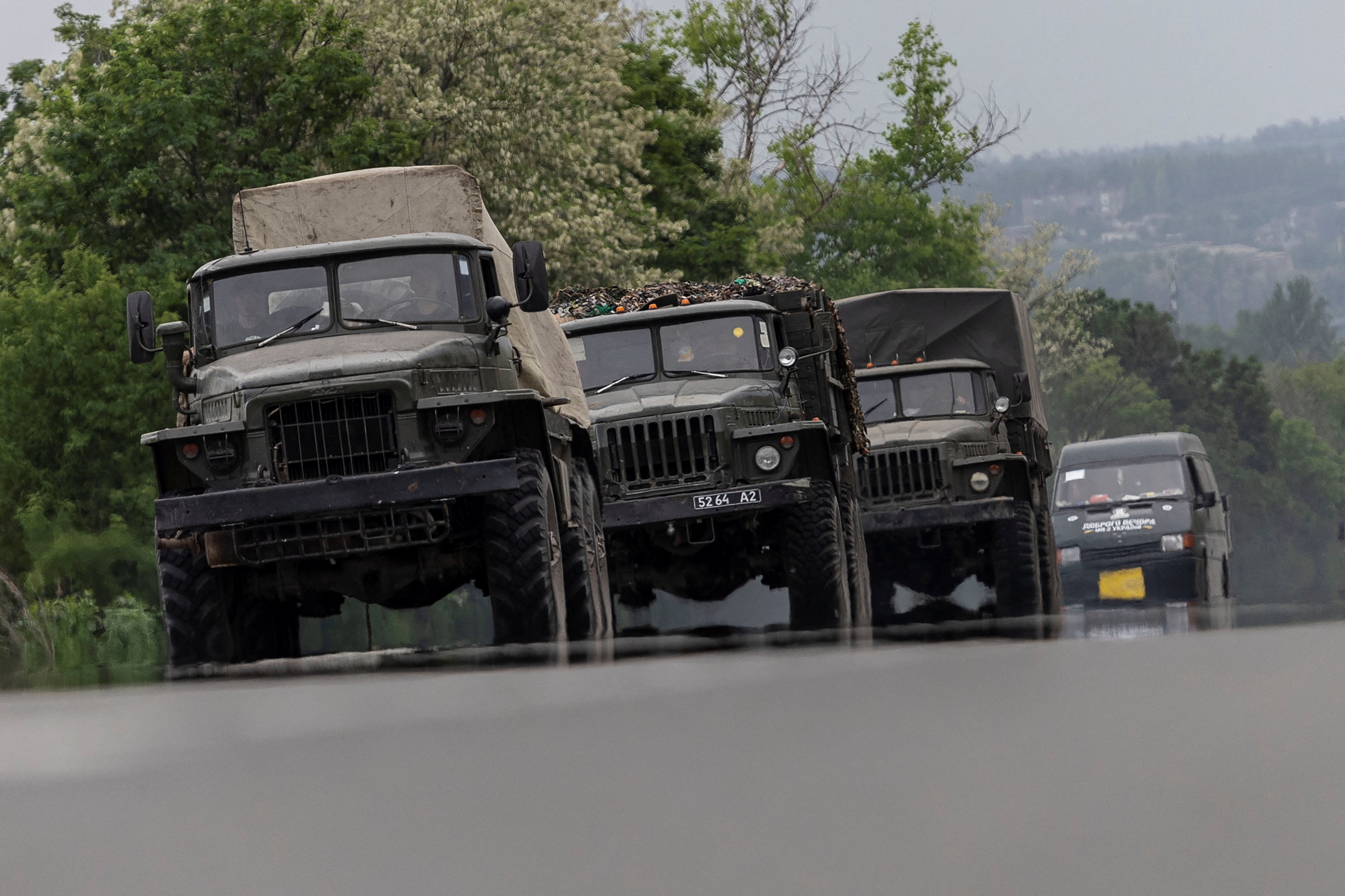 Military vehicles are see moving along a road, amid Russia's invasion of Ukraine, in the Donetsk region