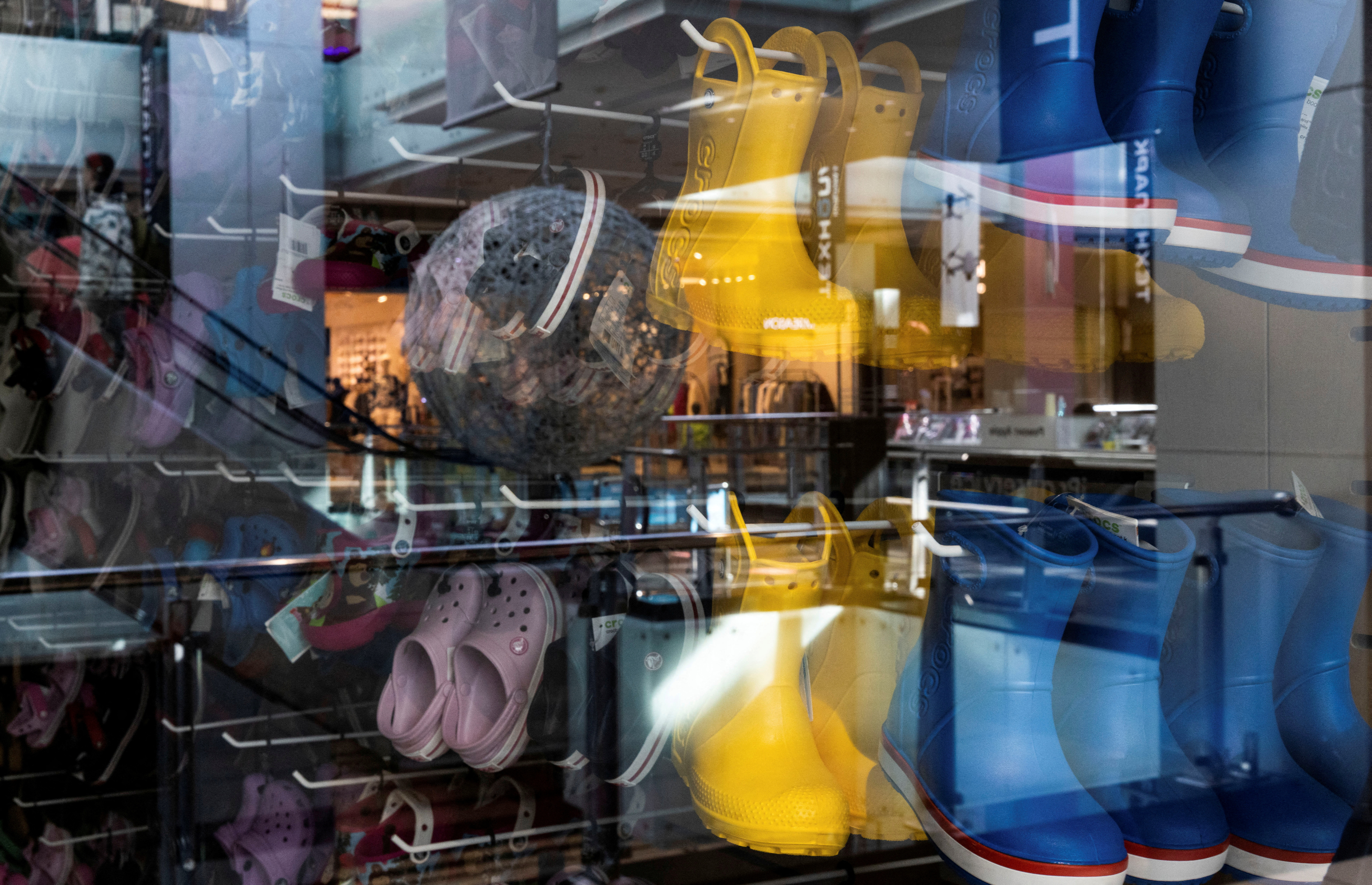 A view through a shop window shows Crocs shoes at a closed store in a shopping mall in Moscow