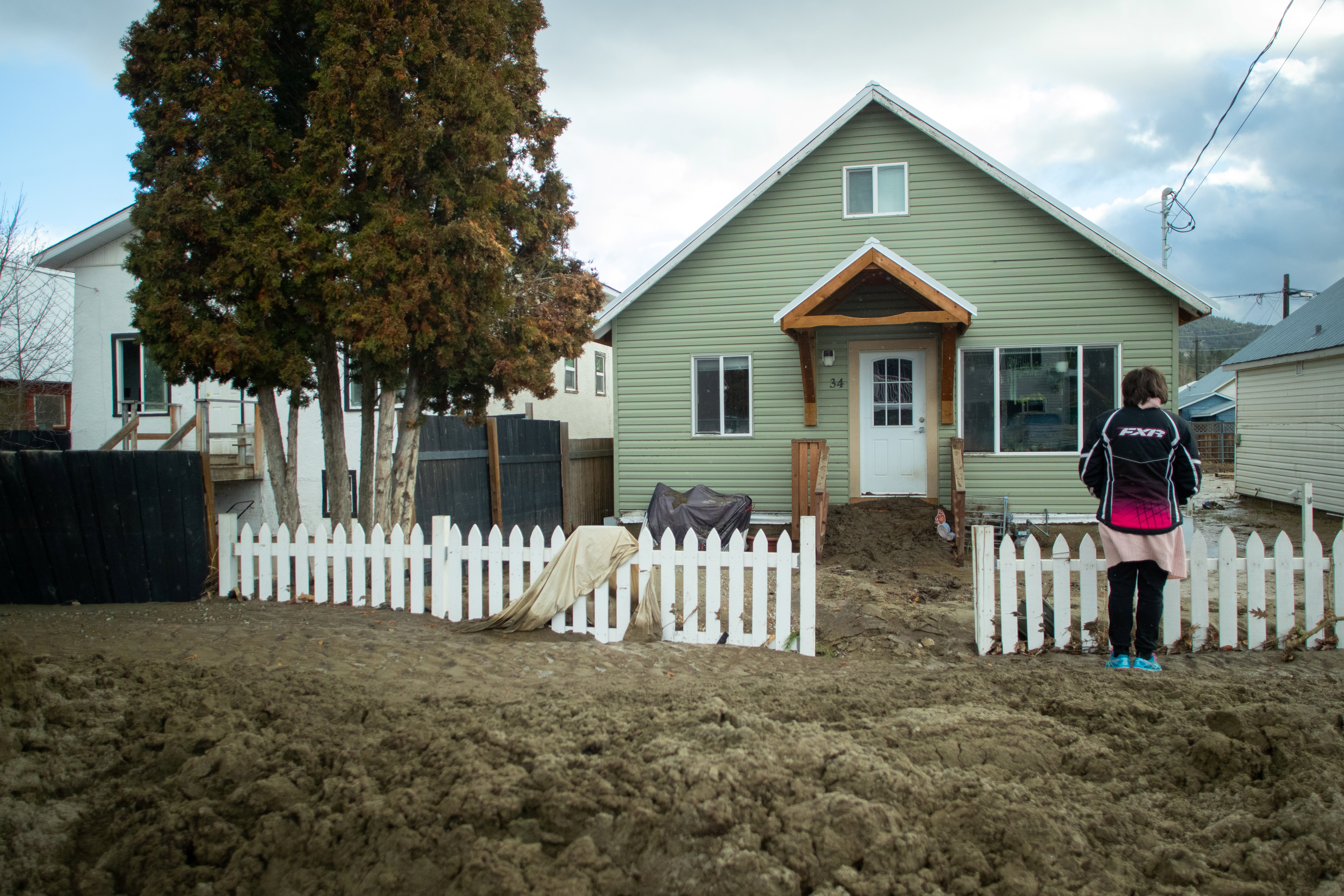 A girl stands in thick mud outside a house a day after severe rain flooded the southern interior town of Princeton, British Columbia, Canada November 16, 2021. REUTERS/Artur Gajda 