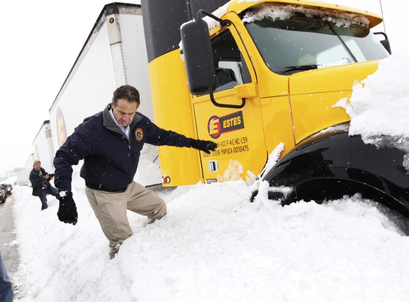 New York Governor Andrew Cuomo climbs over snow piled on the highway after talking with a stranded trucker on interstate I-190 while surveying an area in West Seneca