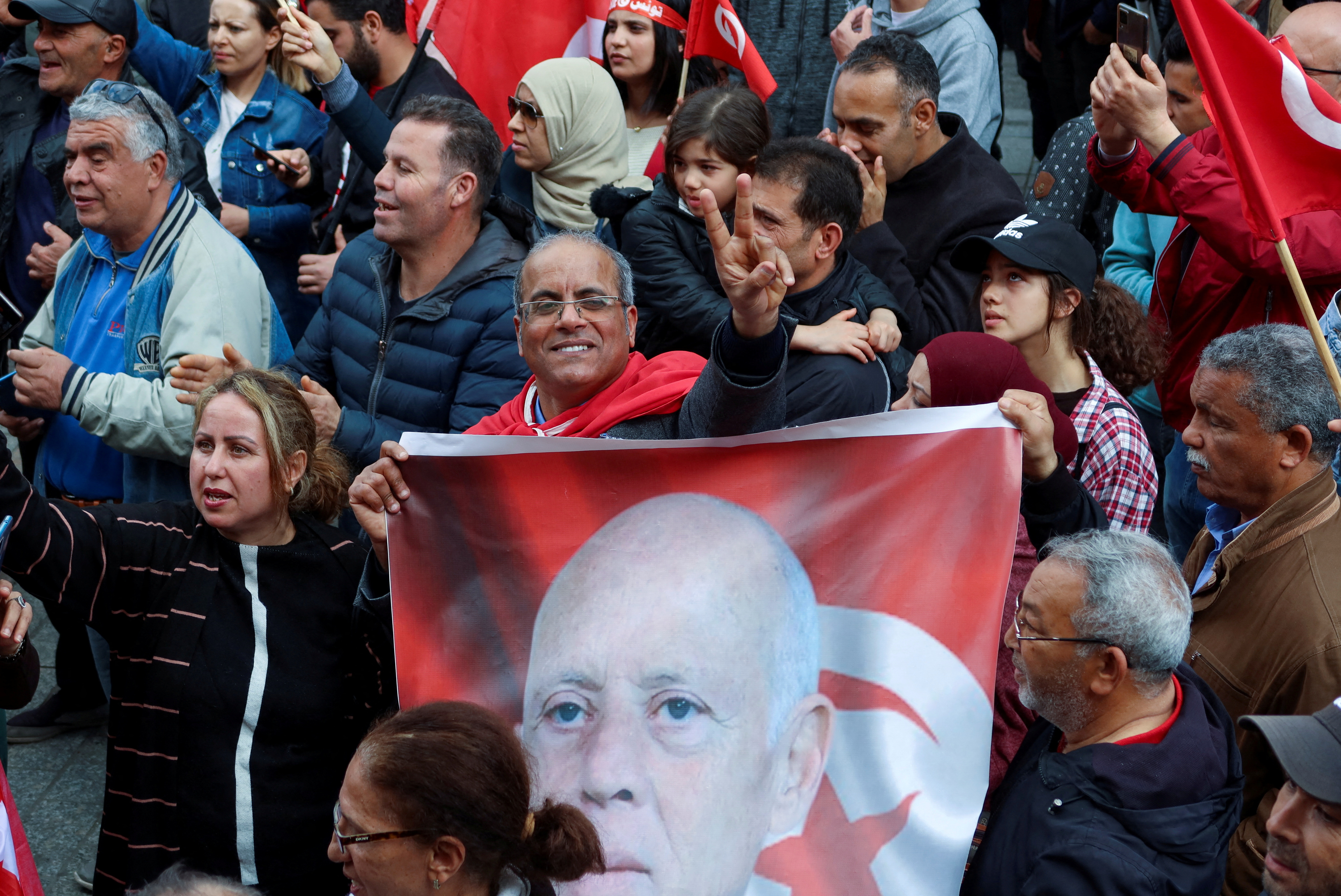 A supporter of Tunisia's President Kais Saied holds a picture of him during a rally in Tunis