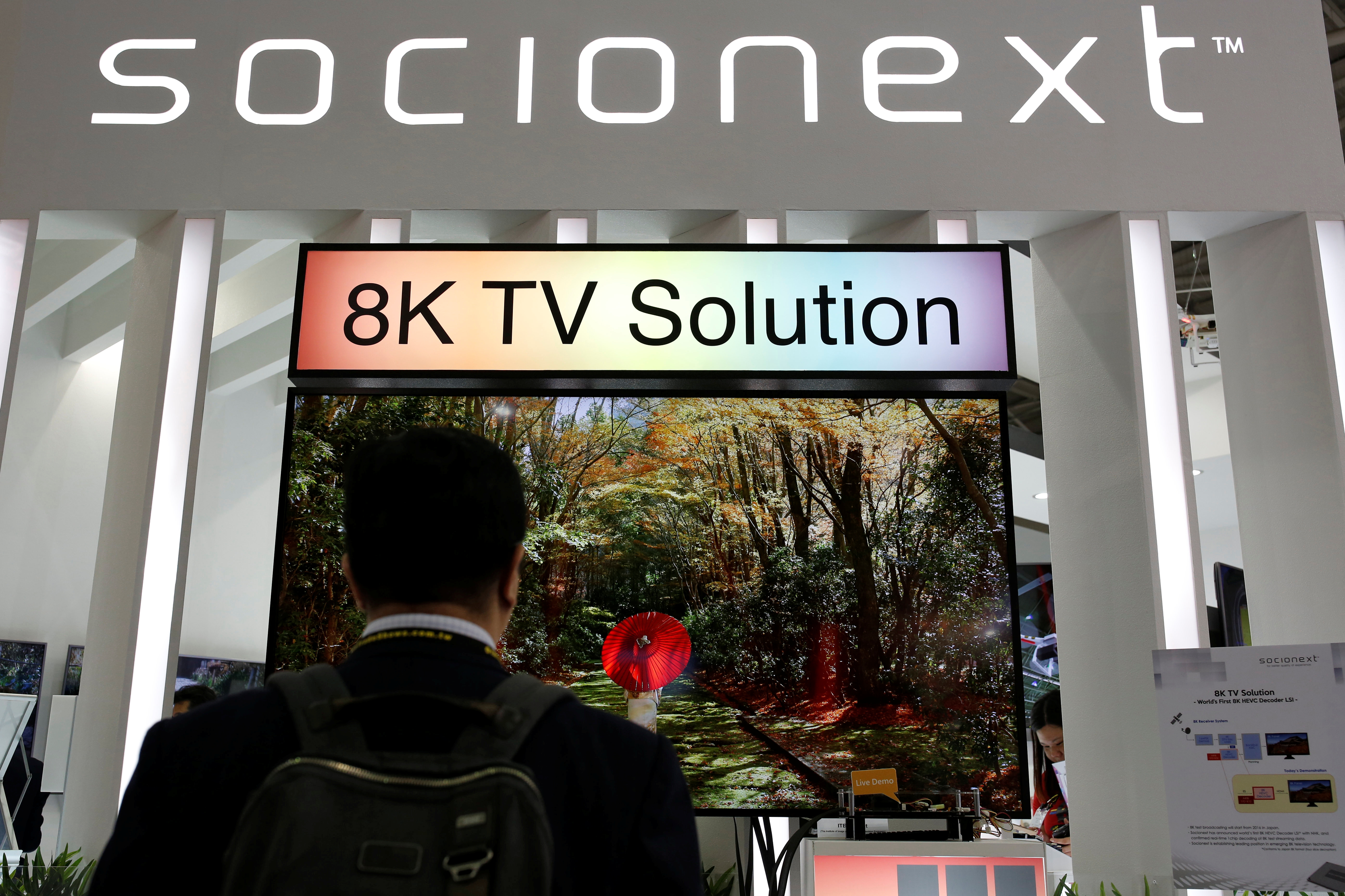 A visiter watches a 8K TV screen at Socionext booth, the Panasonic-Fujitsu SoC joint venture corporation, during the annual Computex computer exhibition in Taipei