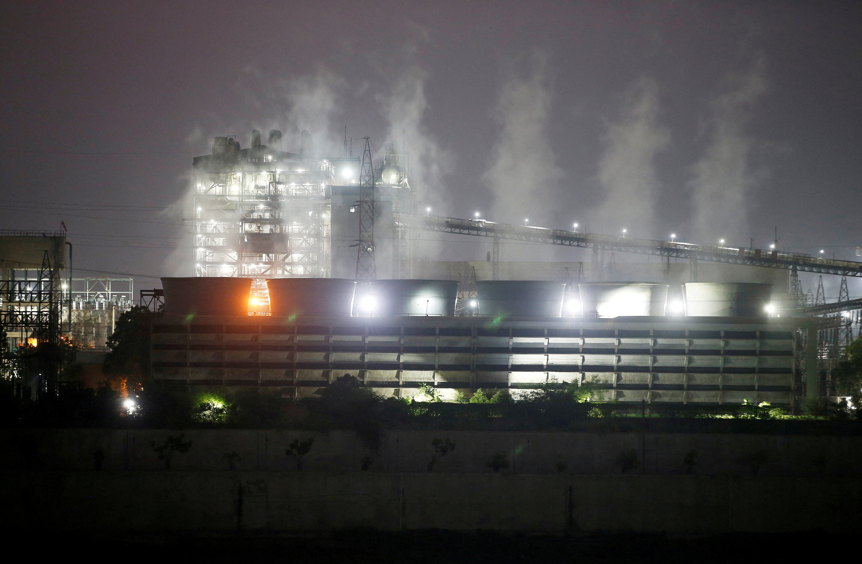 Smoke billows from the cooling towers of a coal-fired power plant in Ahmedabad