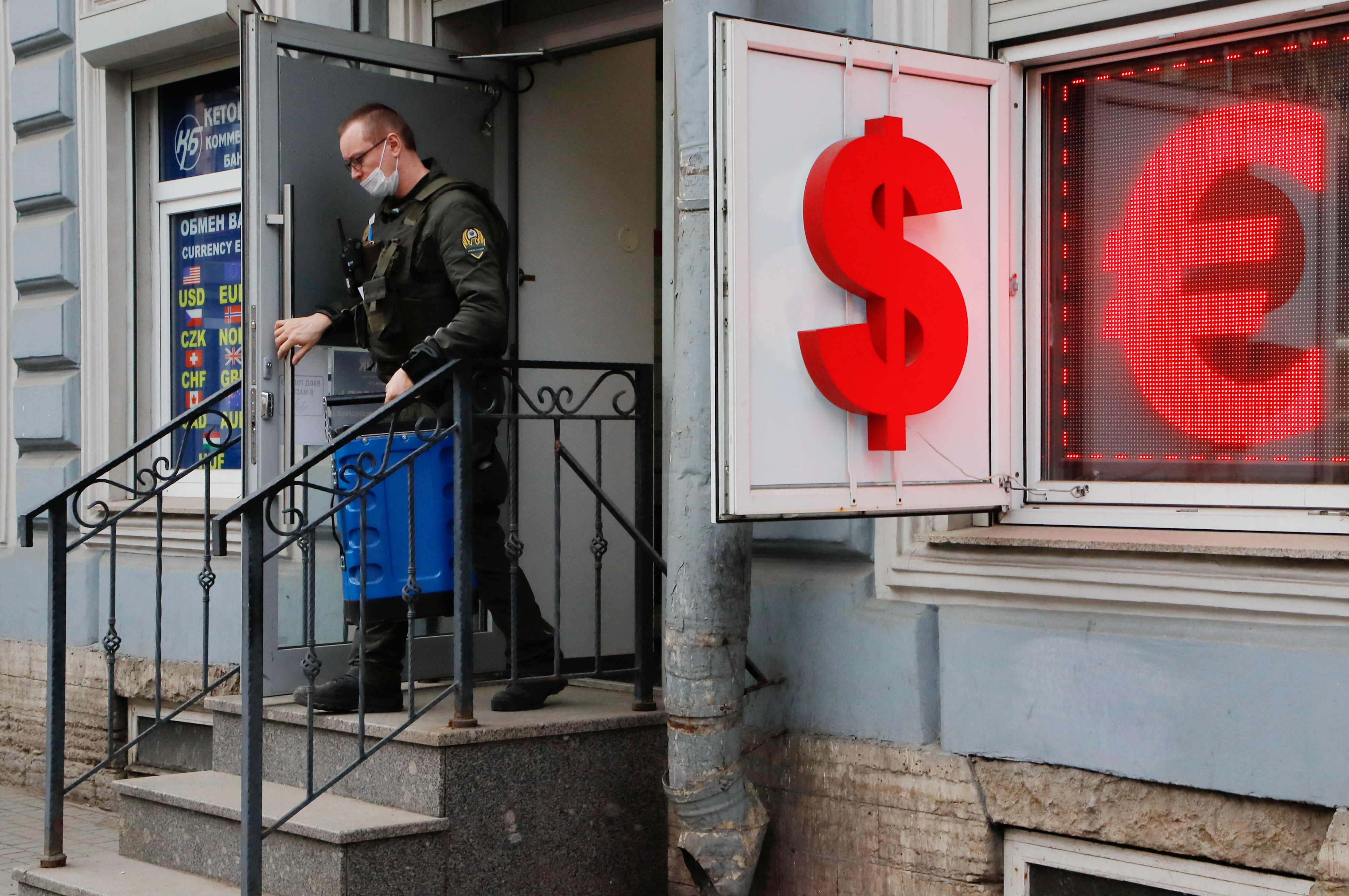 A cash-in-transit worker leaves a currency exchange office in Saint Petersburg