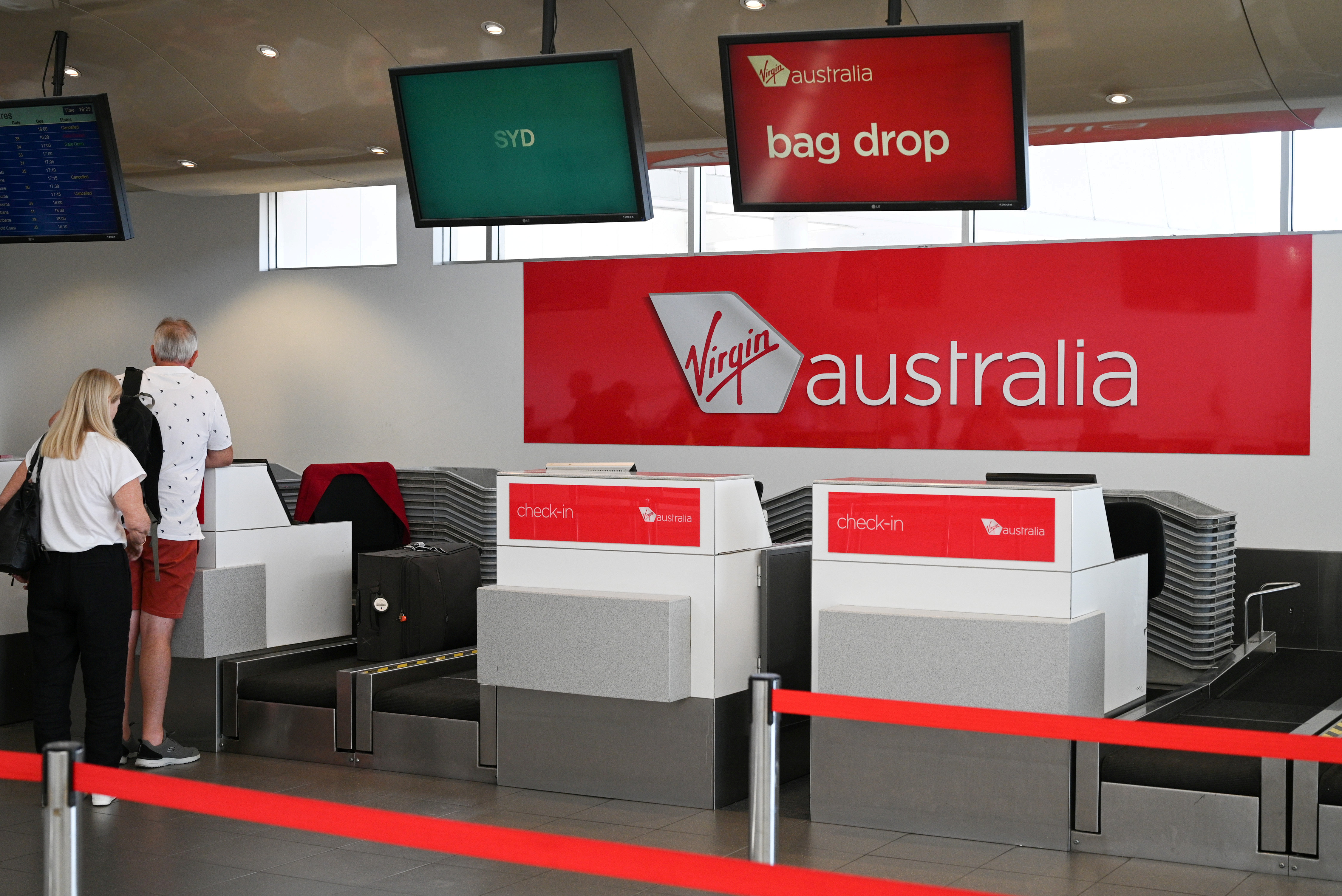 Travelers stand at a Virgin Australia Airlines counter at Kingsford Smith International Airport in Sydney