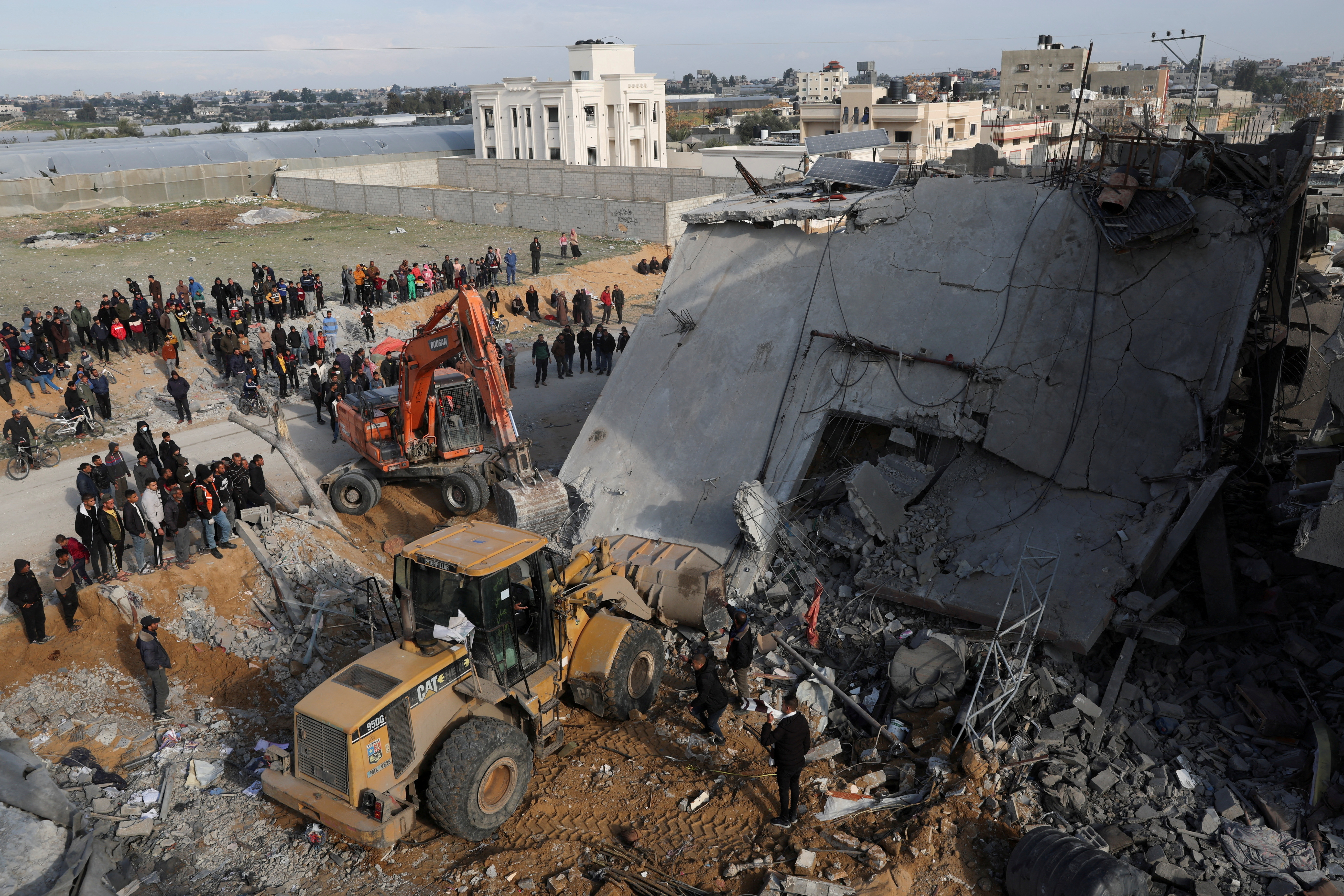 Palestinians inspect a house hit by an Israeli strike, in Rafah in the southern Gaza Strip