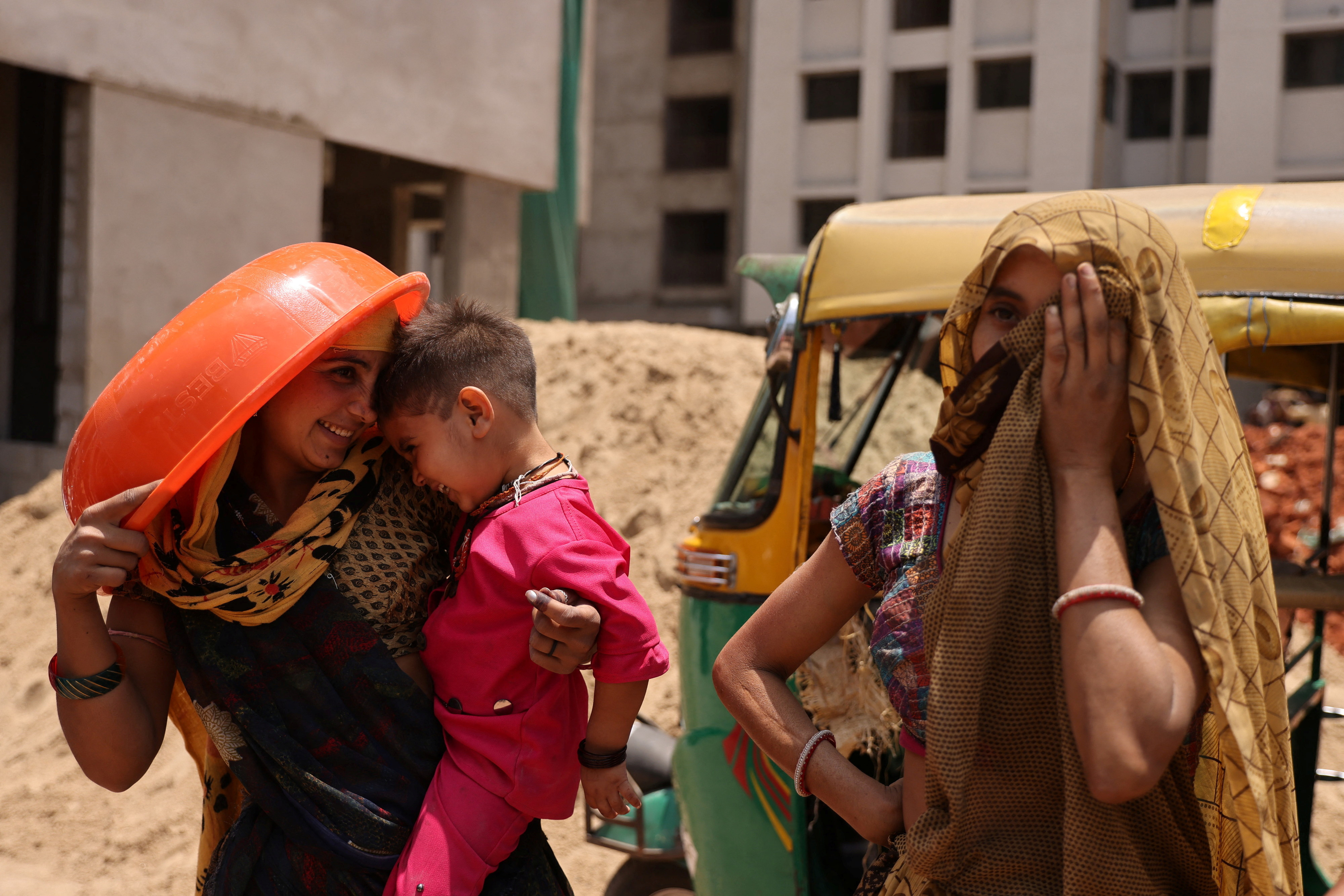 Women take shelter from the sun at a construction site in Ahmedabad