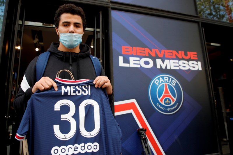 A fan poses with a Paris St Germain Lionel Messi football jersey after buying it from a Paris St Germain shop in Paris, France, August 11, 2021. REUTERS/Sarah Meyssonnier