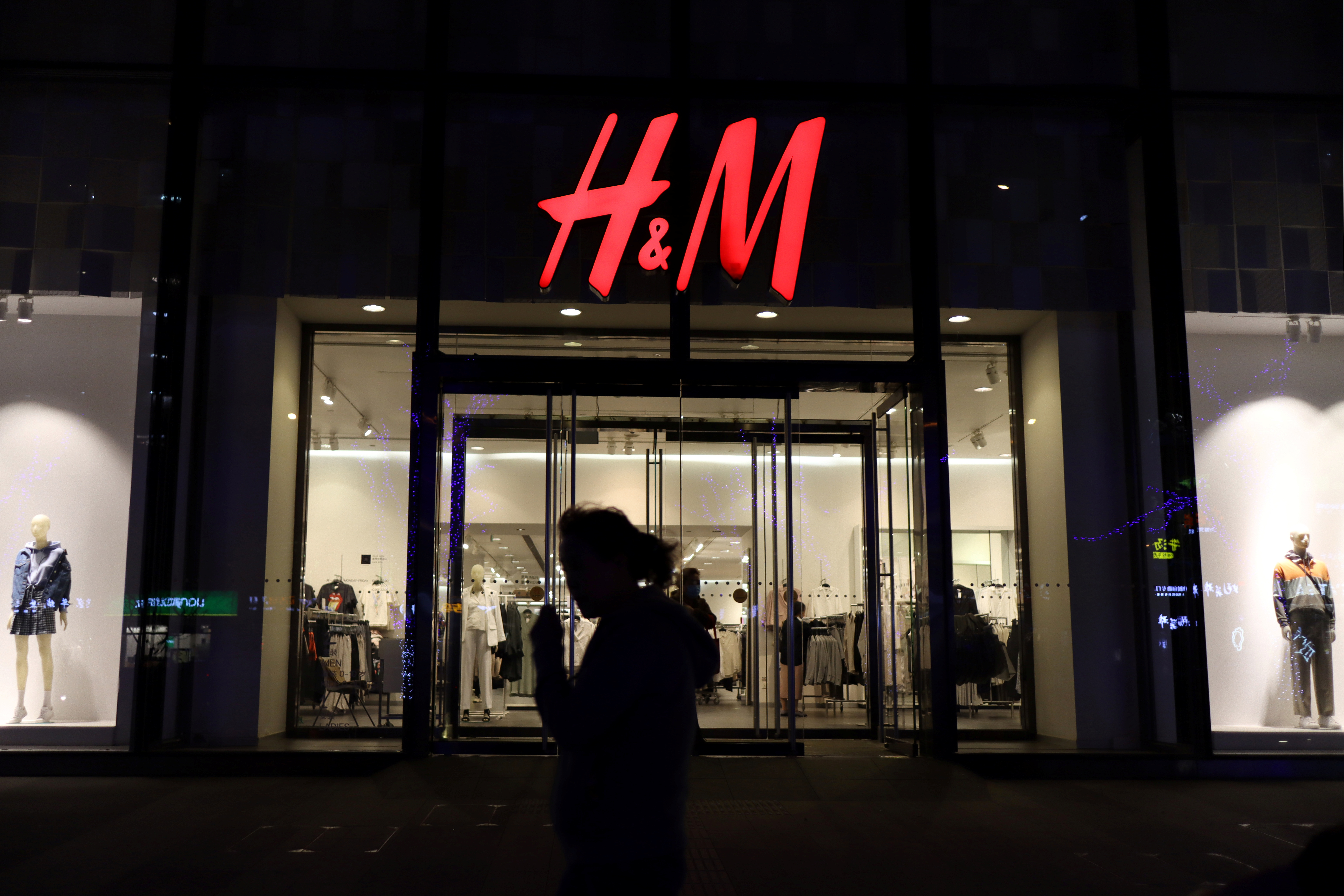 Woman walks past an H&M store at a shopping mall in Beijing
