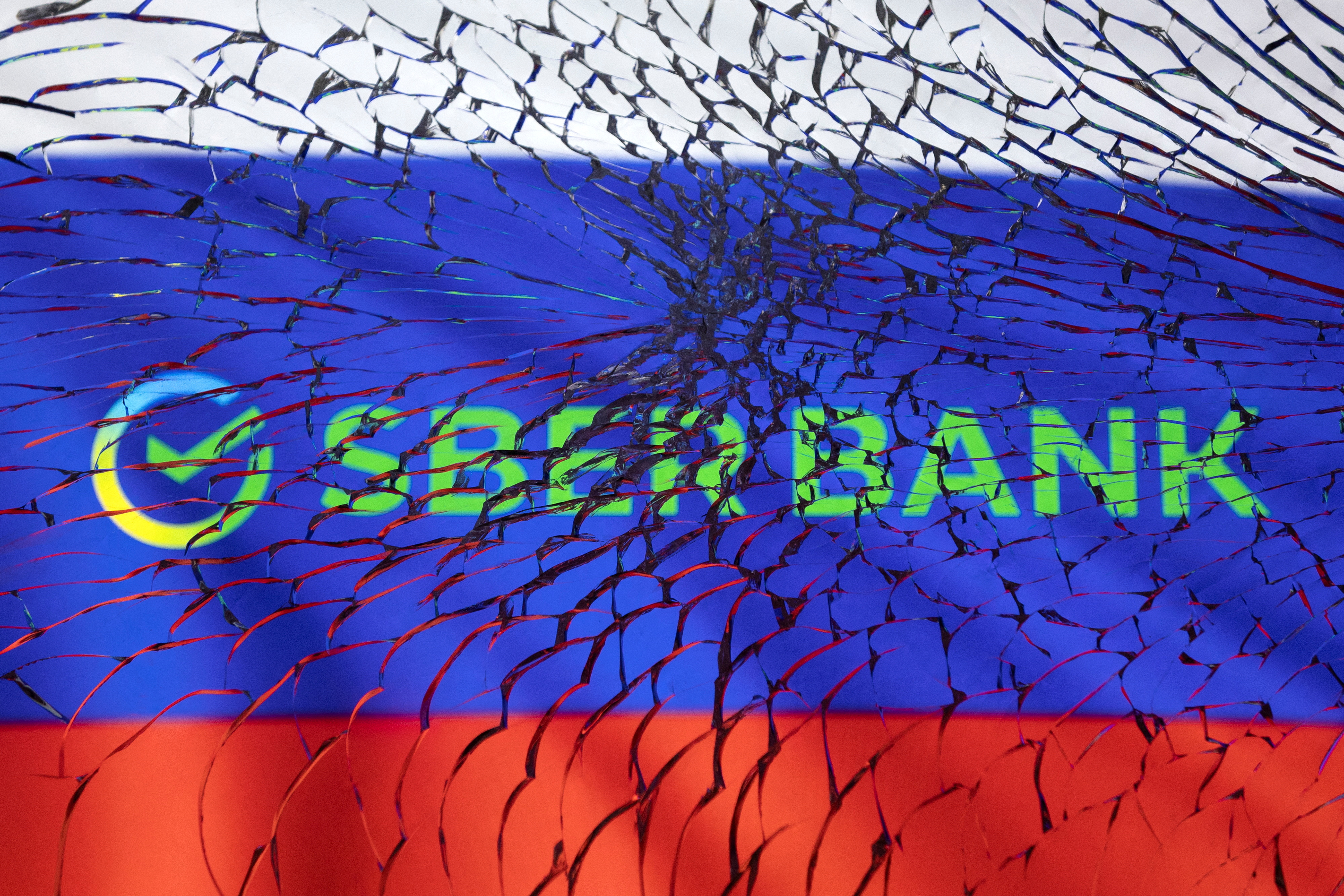 Illustration shows Sberbank logo and Russian flag through broken glass