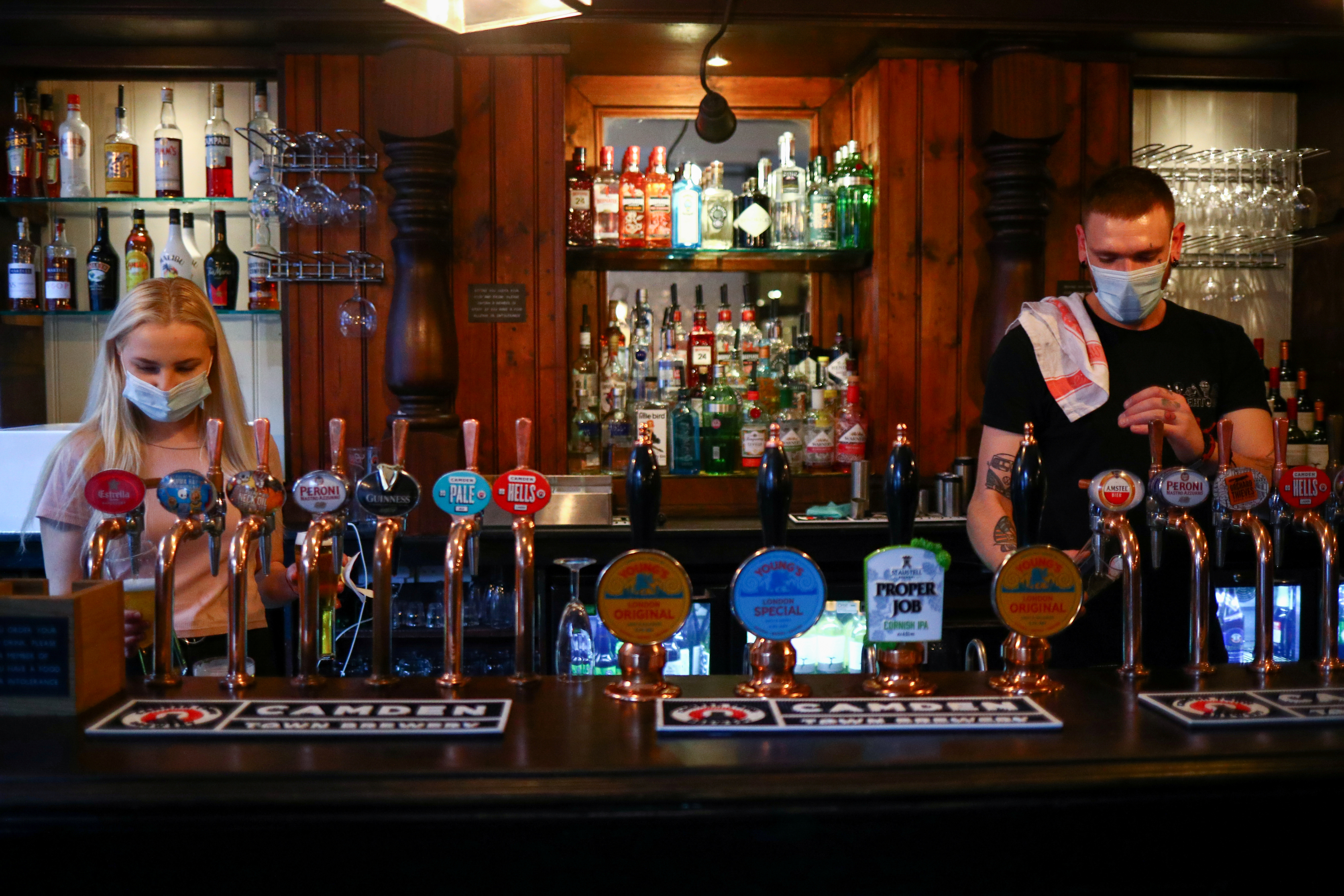 Bartenders pour drinks in a pub in London Bridge amid the outbreak of the coronavirus disease (COVID-19) in London