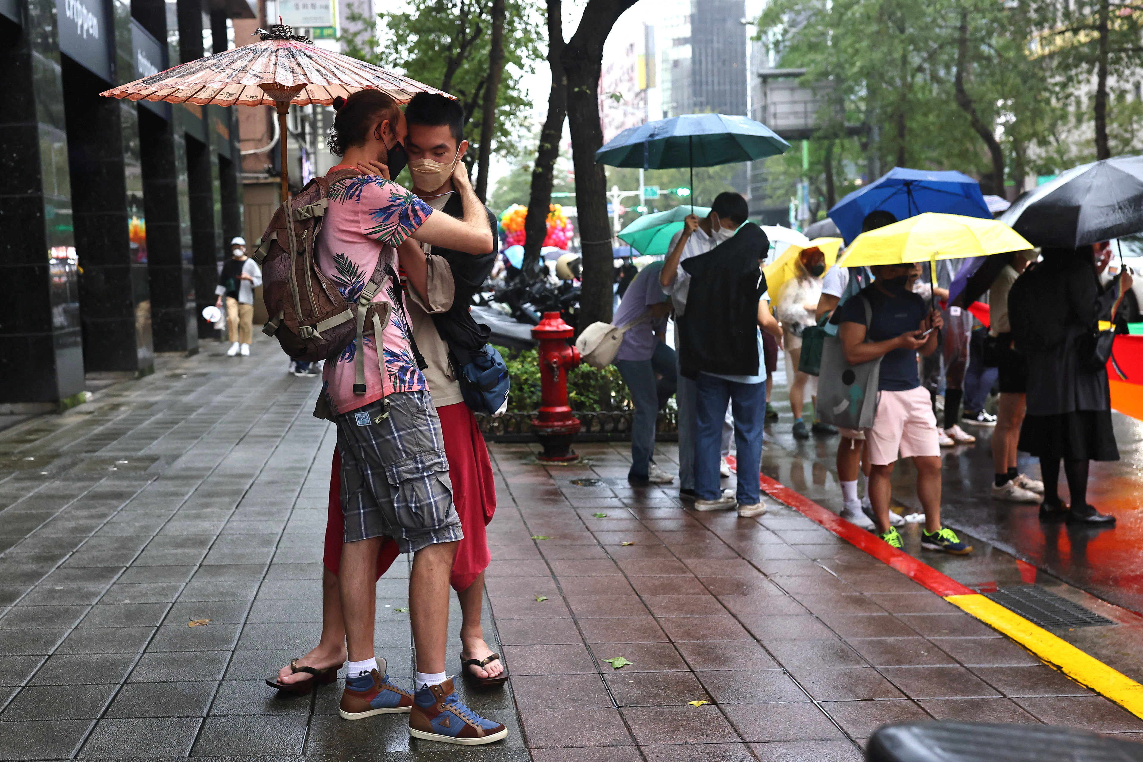 People embrace each other during the annual pride parade in Taipei