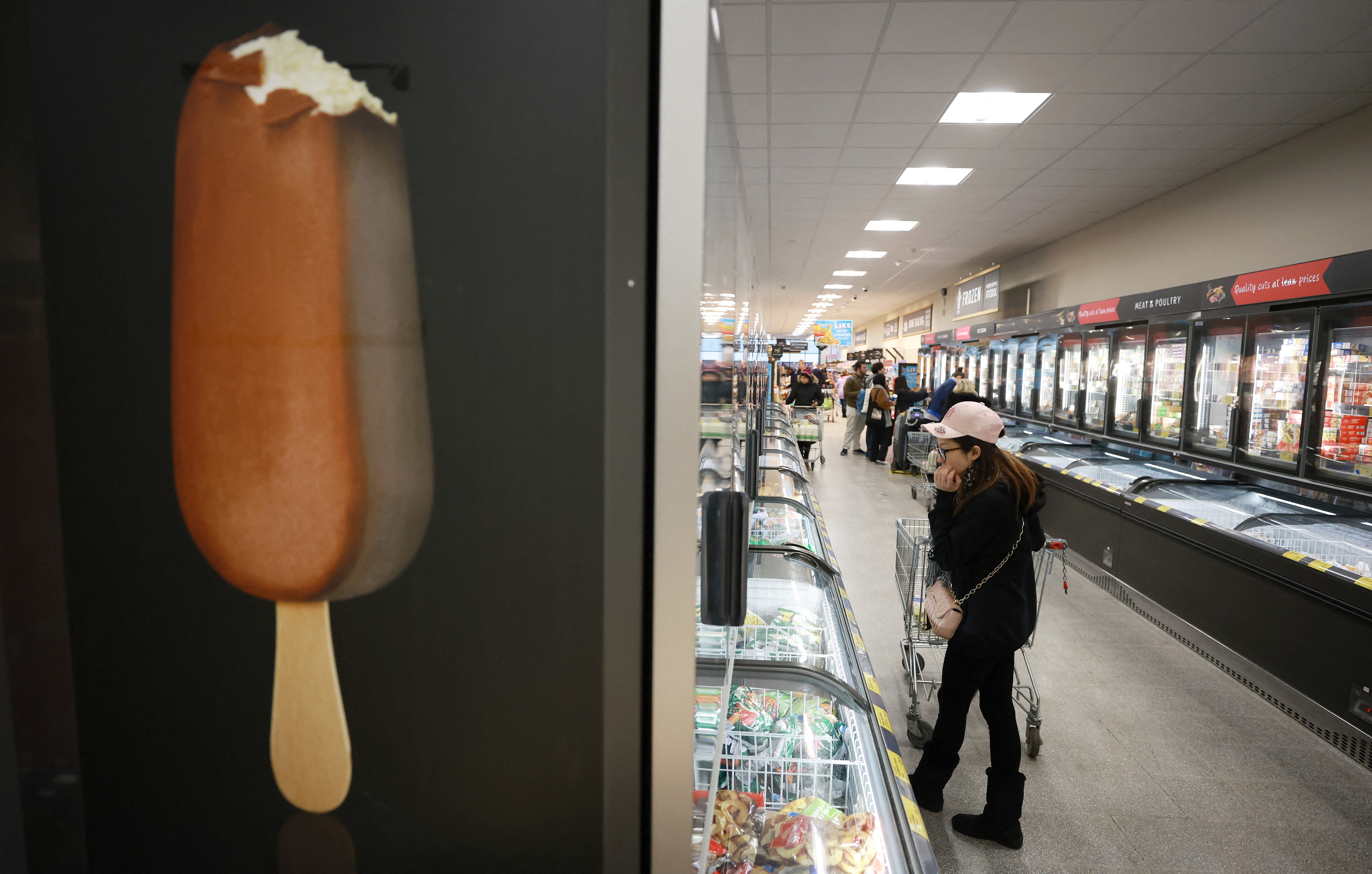 Shopper walks along the frozen food aisle inside an ALDI supermarket near Altrincham