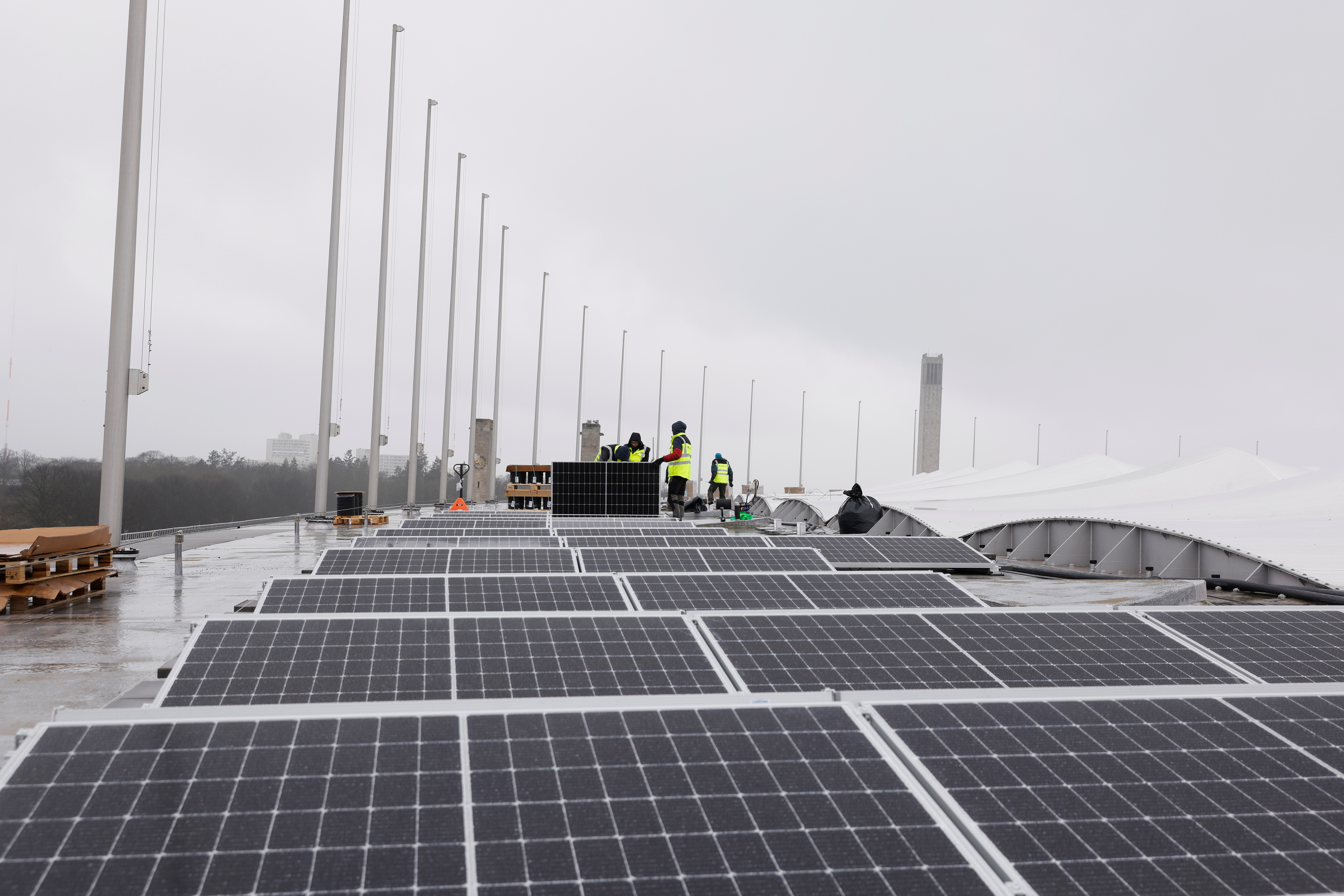 Workers mount solar panels on the roof of the Olympic Stadium or Olympiastadion in Berlin
