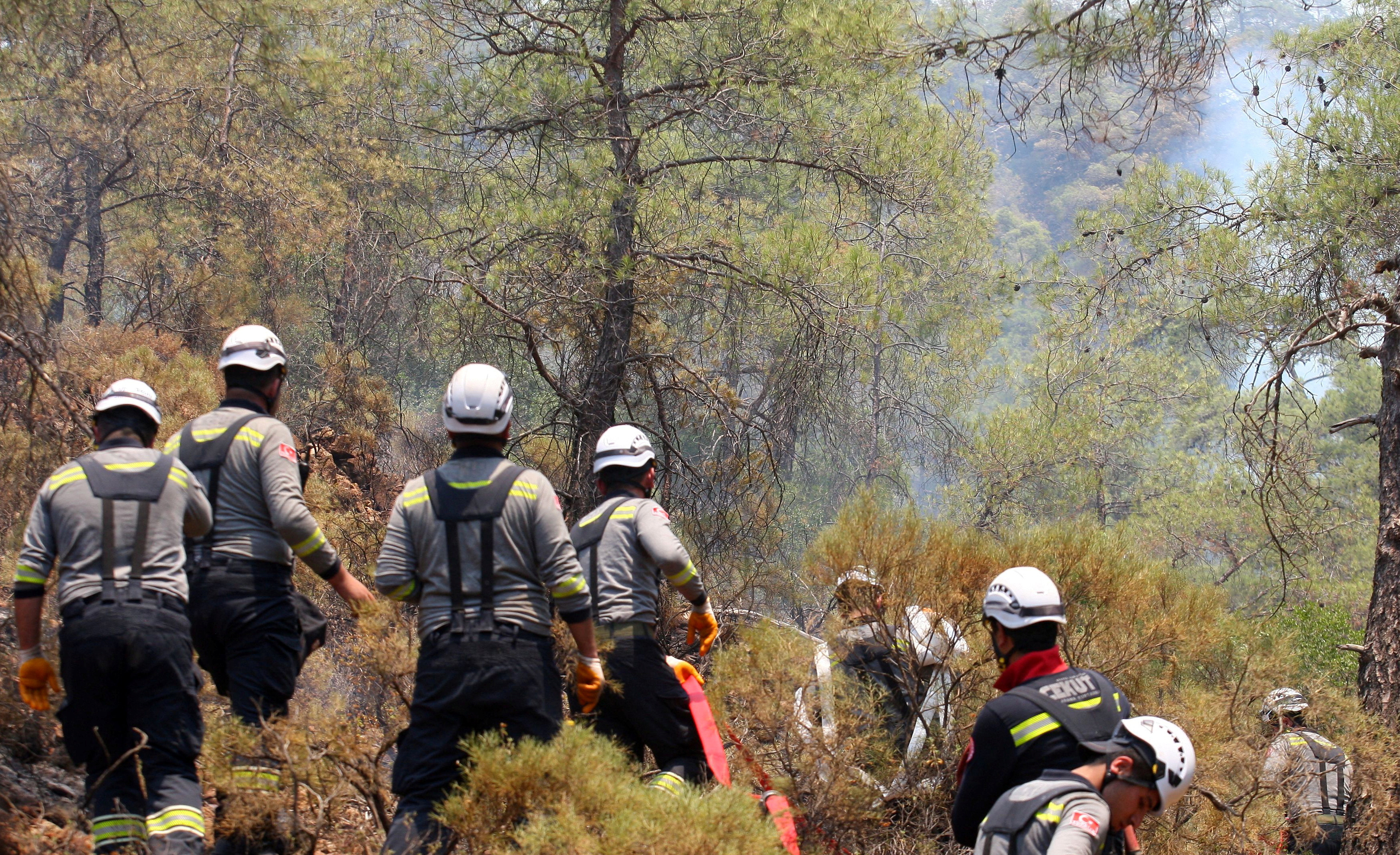 Firefighters work to extinguish a wildfire near Marmaris