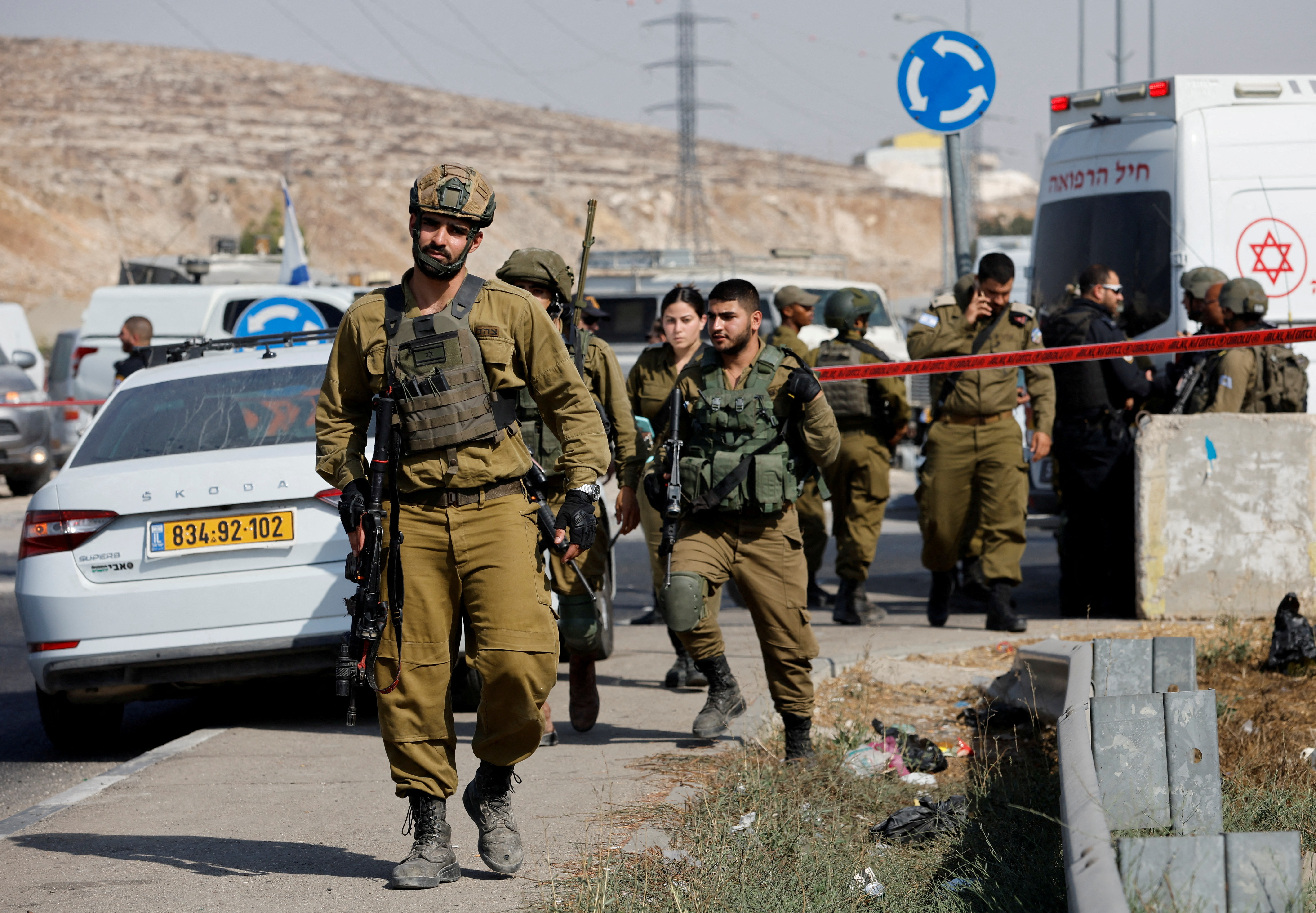 Israeli troops stands guard at a scene of stabbing incident near Hebron