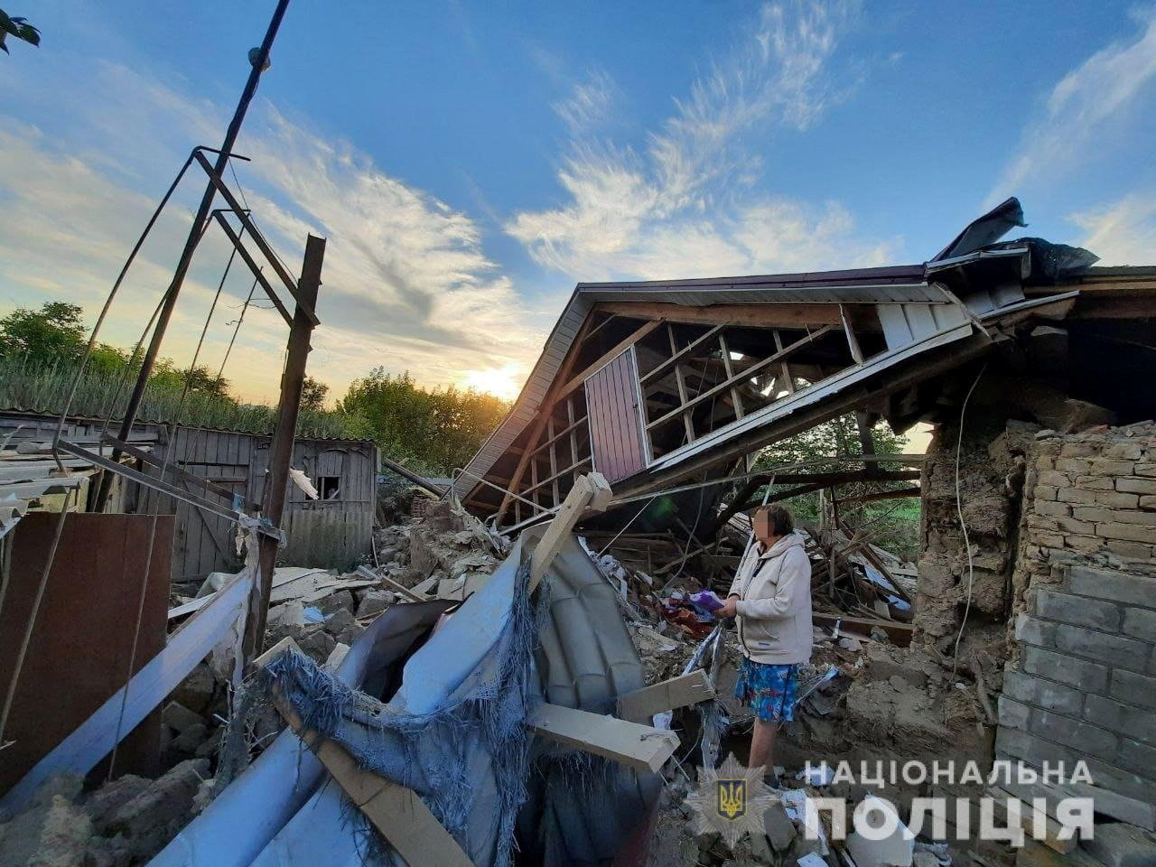 A local resident stands next to a house destroyed by a Russian military strike in location given as Marhanets town