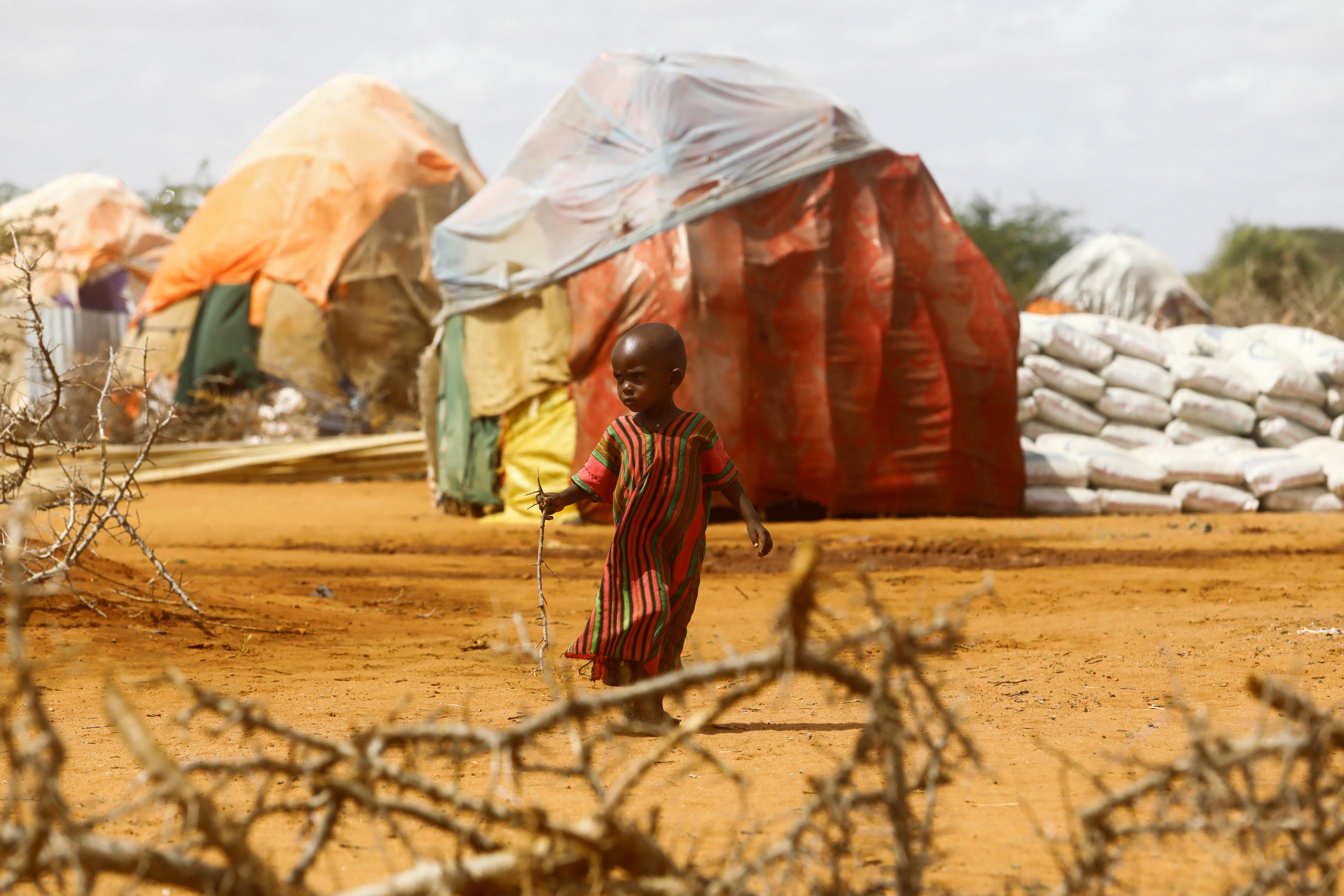 A child walks outside makeshift shelters at the Kaxareey camp for the internally displaced people after they fled from the severe droughts, in Dollow