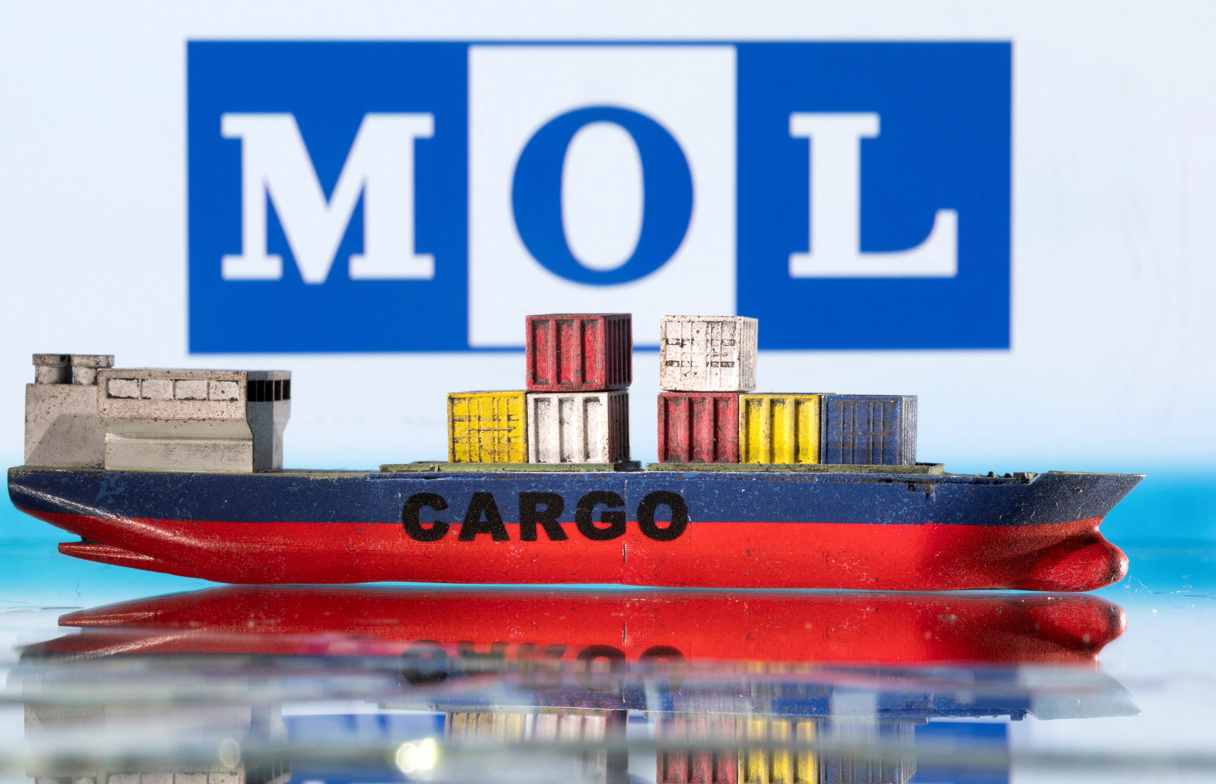 Illustration shows cargo boat model and Mitsui O.S.K. Lines (MOL) logo