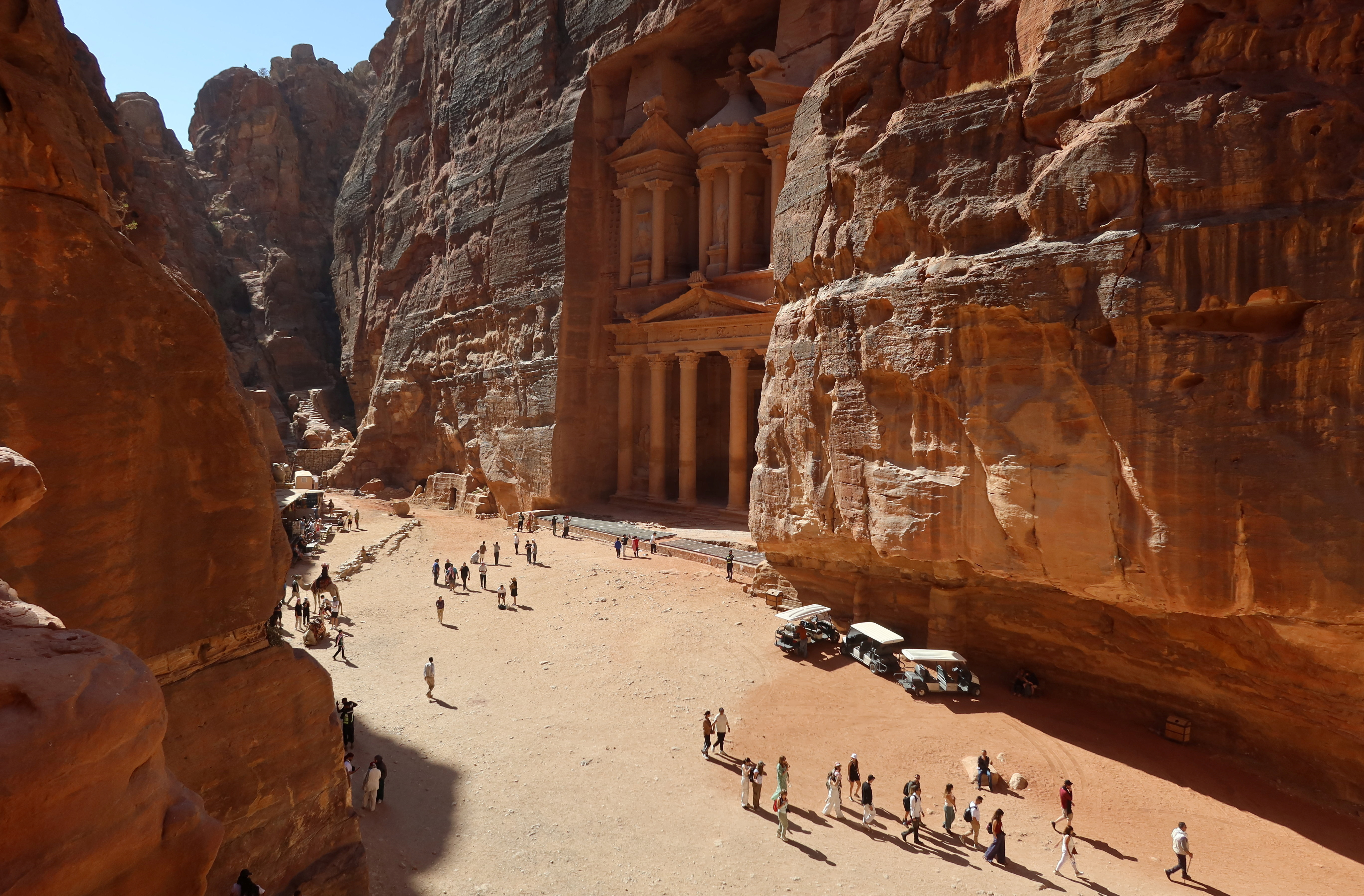 Visitors walk near the treasury site in the ancient city of Petra