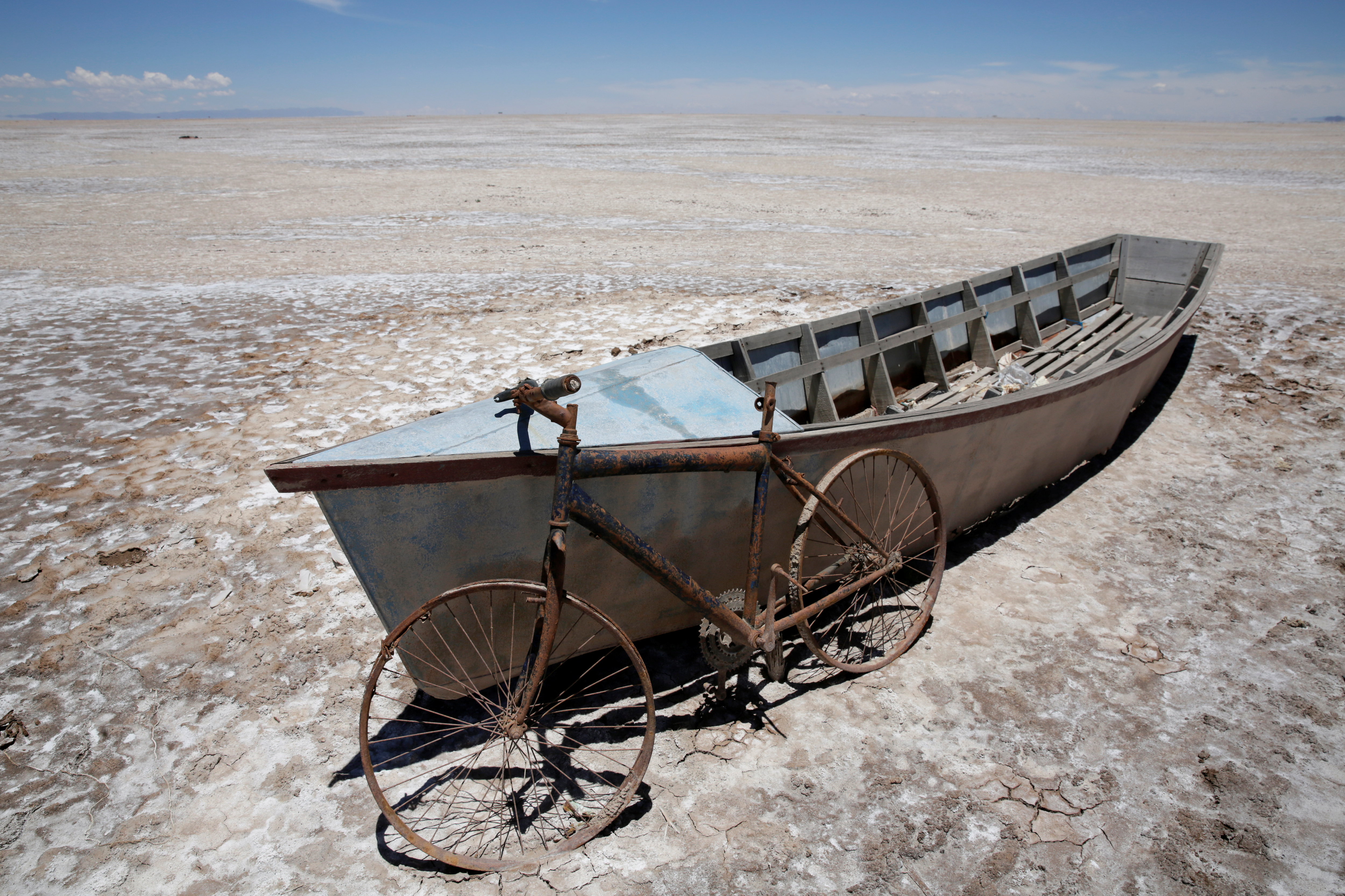 A boat and a bicycle are seen on dried lake Poopo affected by climate change, in the Oruro