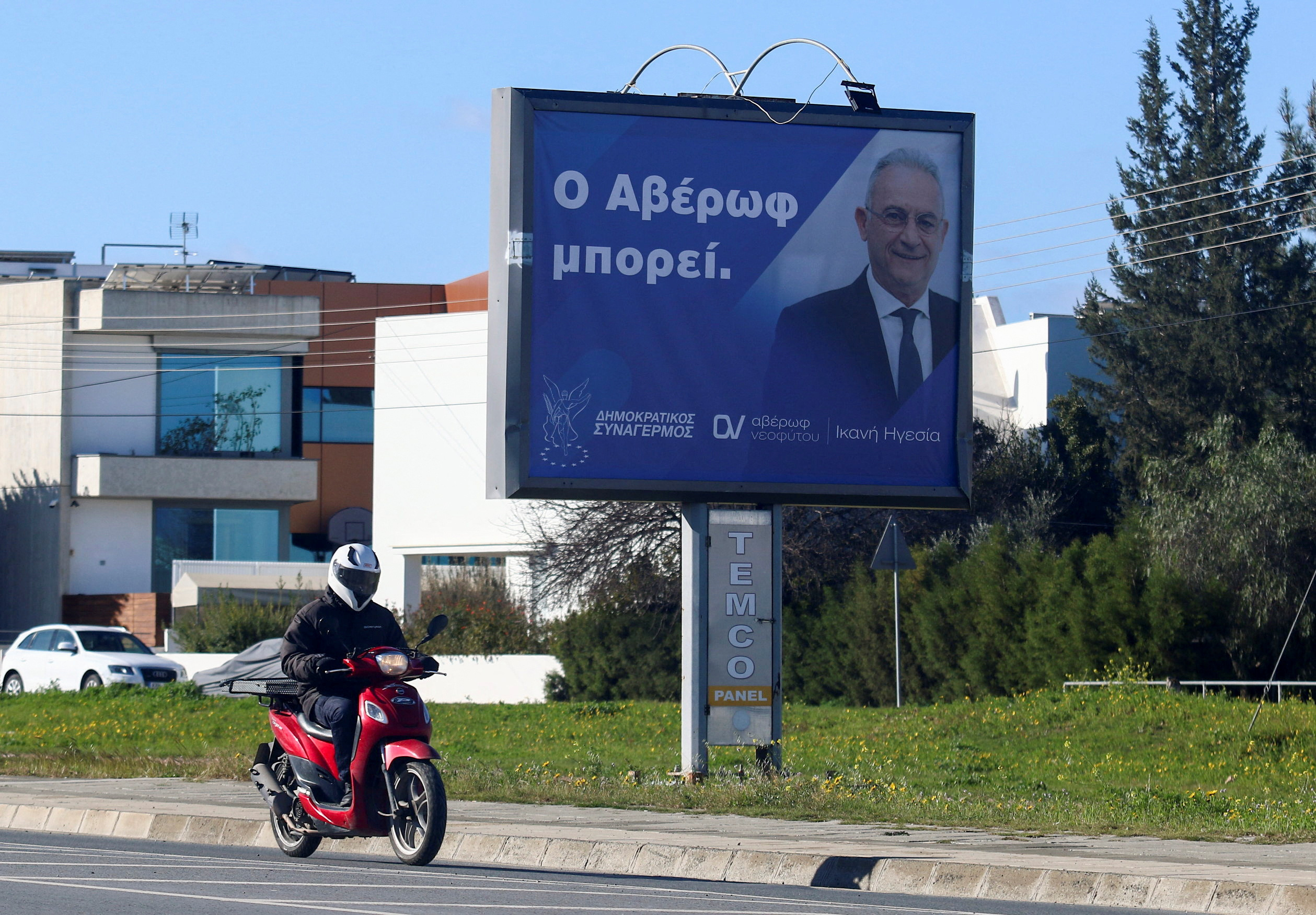 A motorcyclist rides past a billboard of Cypriot presidential candidate Averof Neophytou in Nicosia