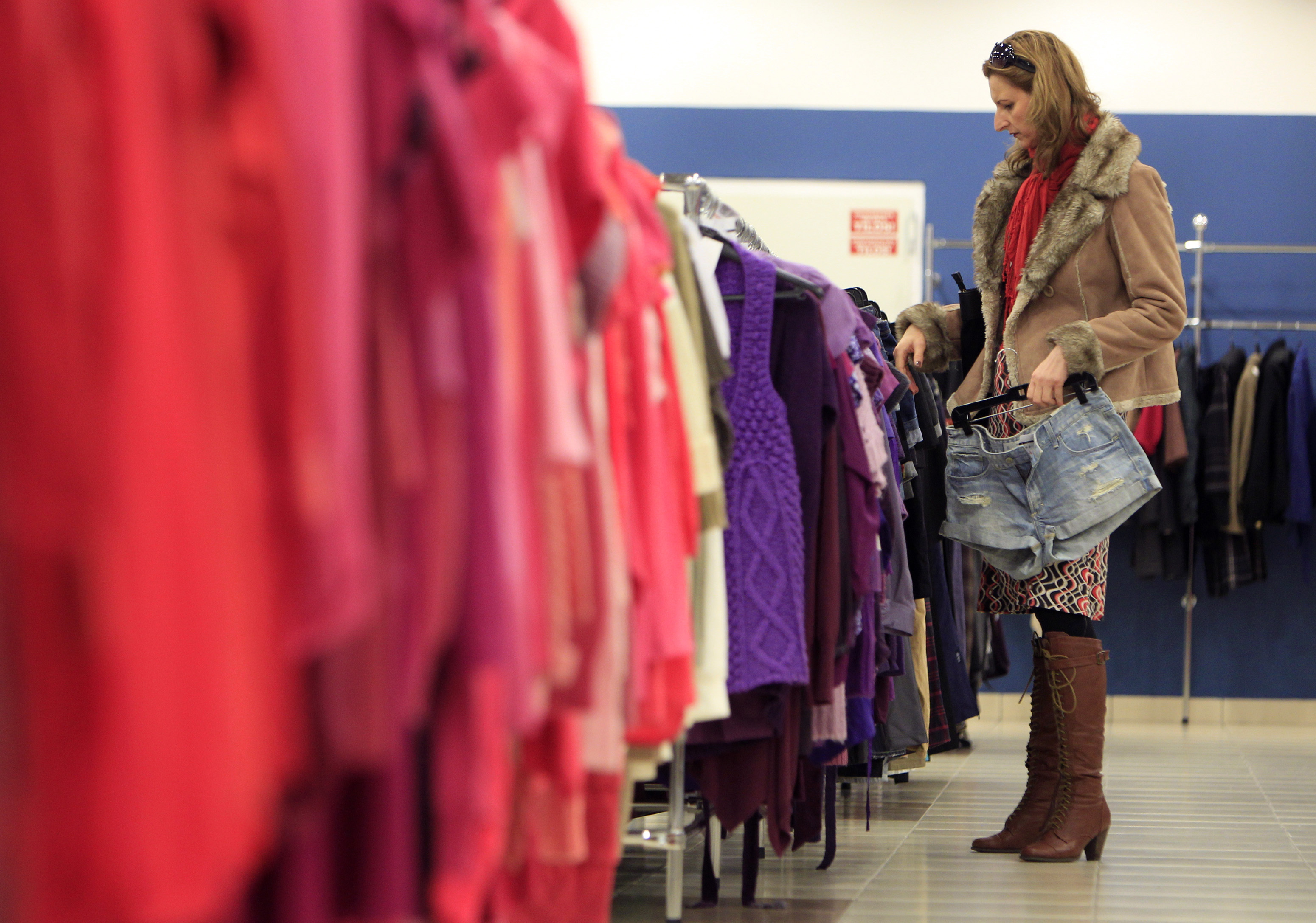 A customer looks at clothes on display at a store of a major second=hand clothes importer in Hungary, in Budapest