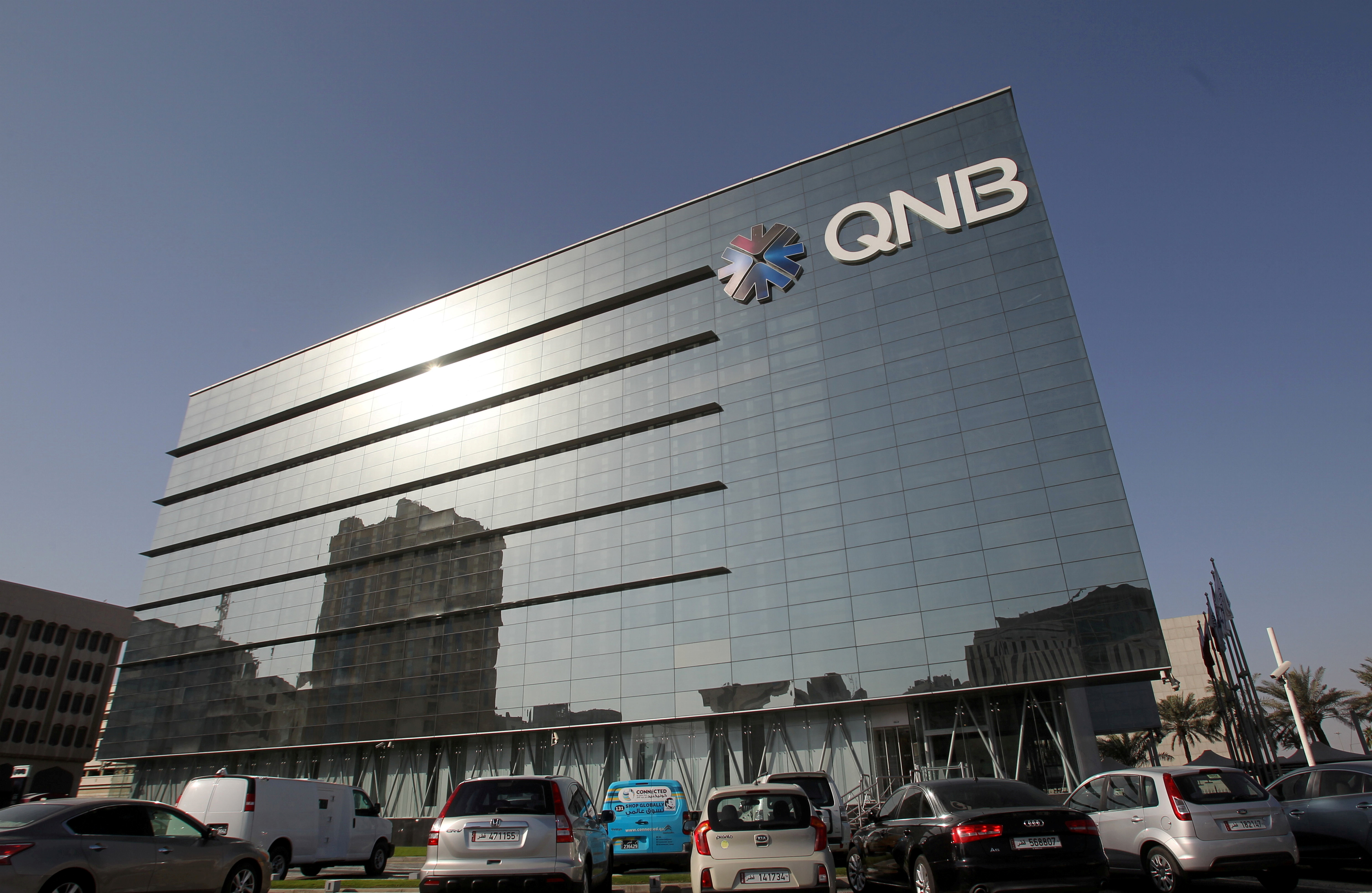 Cars are parked outside the building of Qatar National Bank in Doha