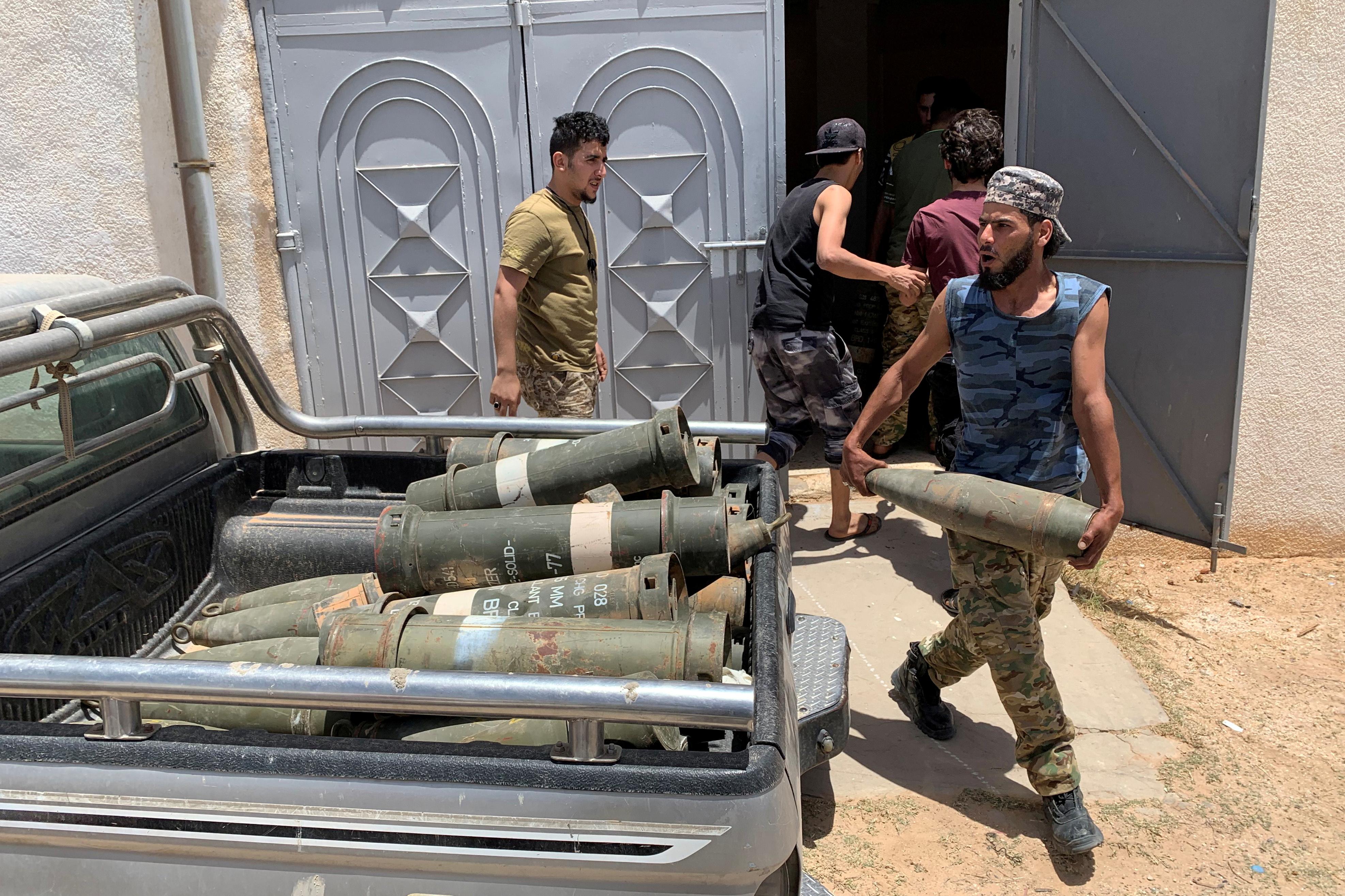 A fighter loyal to Libya's internationally recognised government carries confiscated weapons after regaining control over Tarhouna city