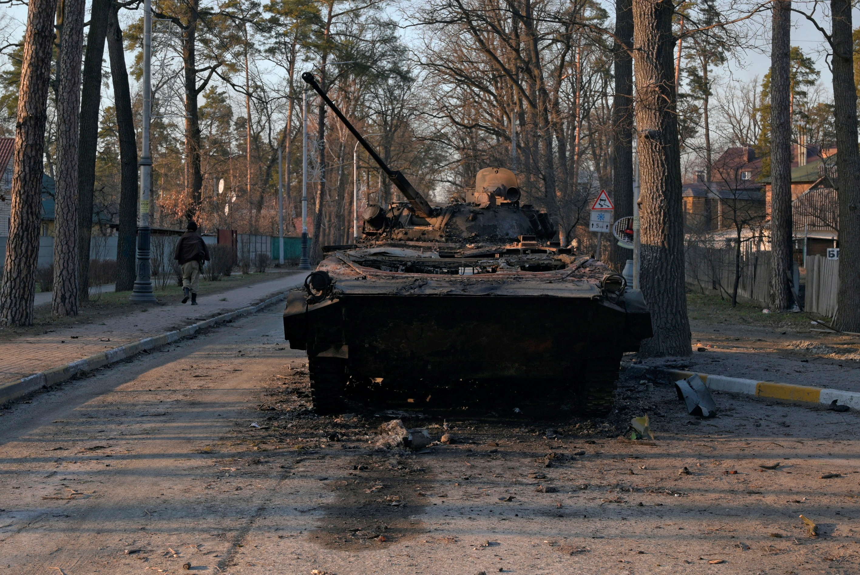 A charred armoured vehicle is seen on a street in Bucha