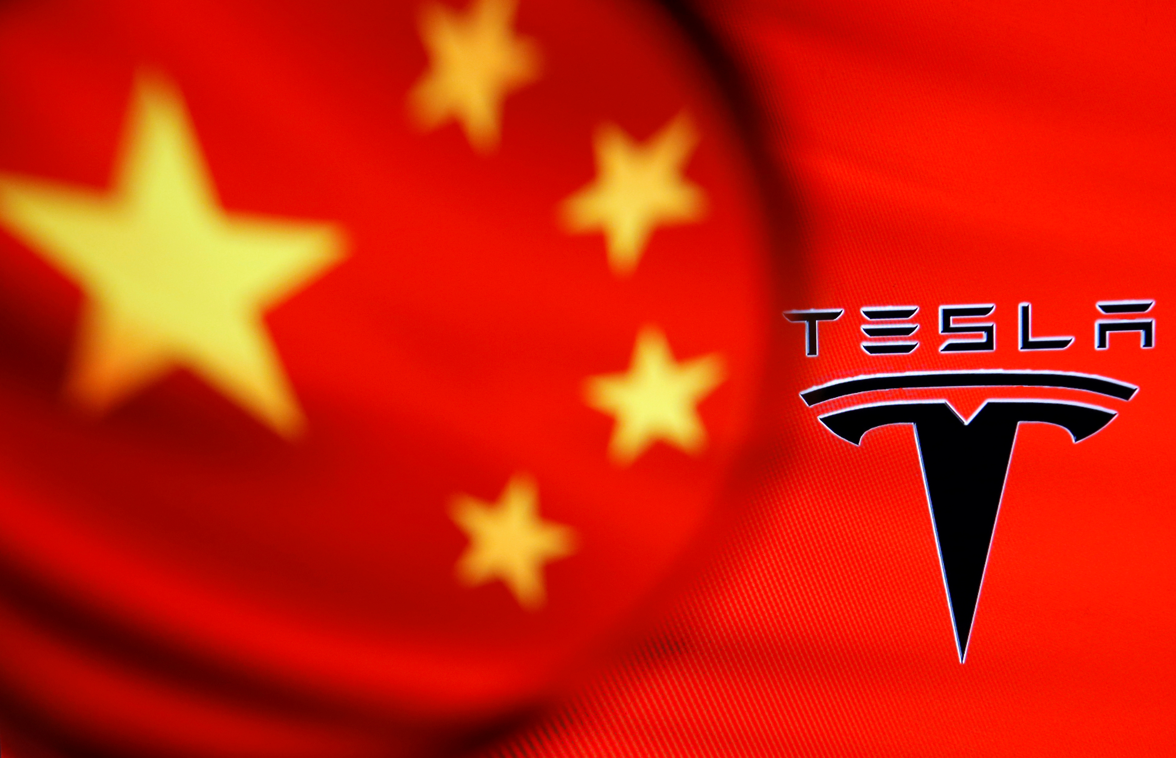 Chinese flag and Tesla logo is seen through a magnifier in this illustration