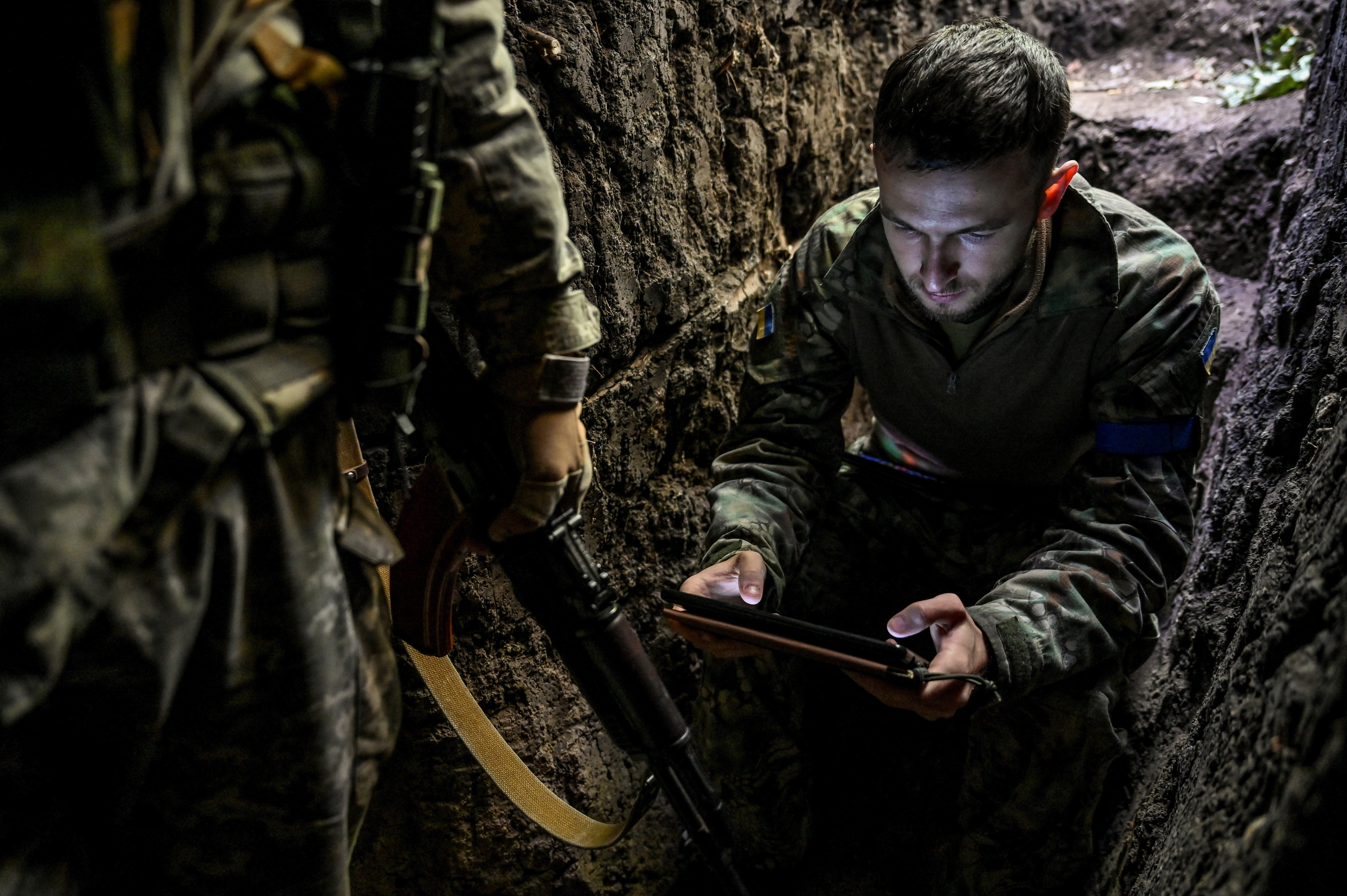 Ukrainian service members wait in a trench at a position in a frontline in Zaporizhzhia region