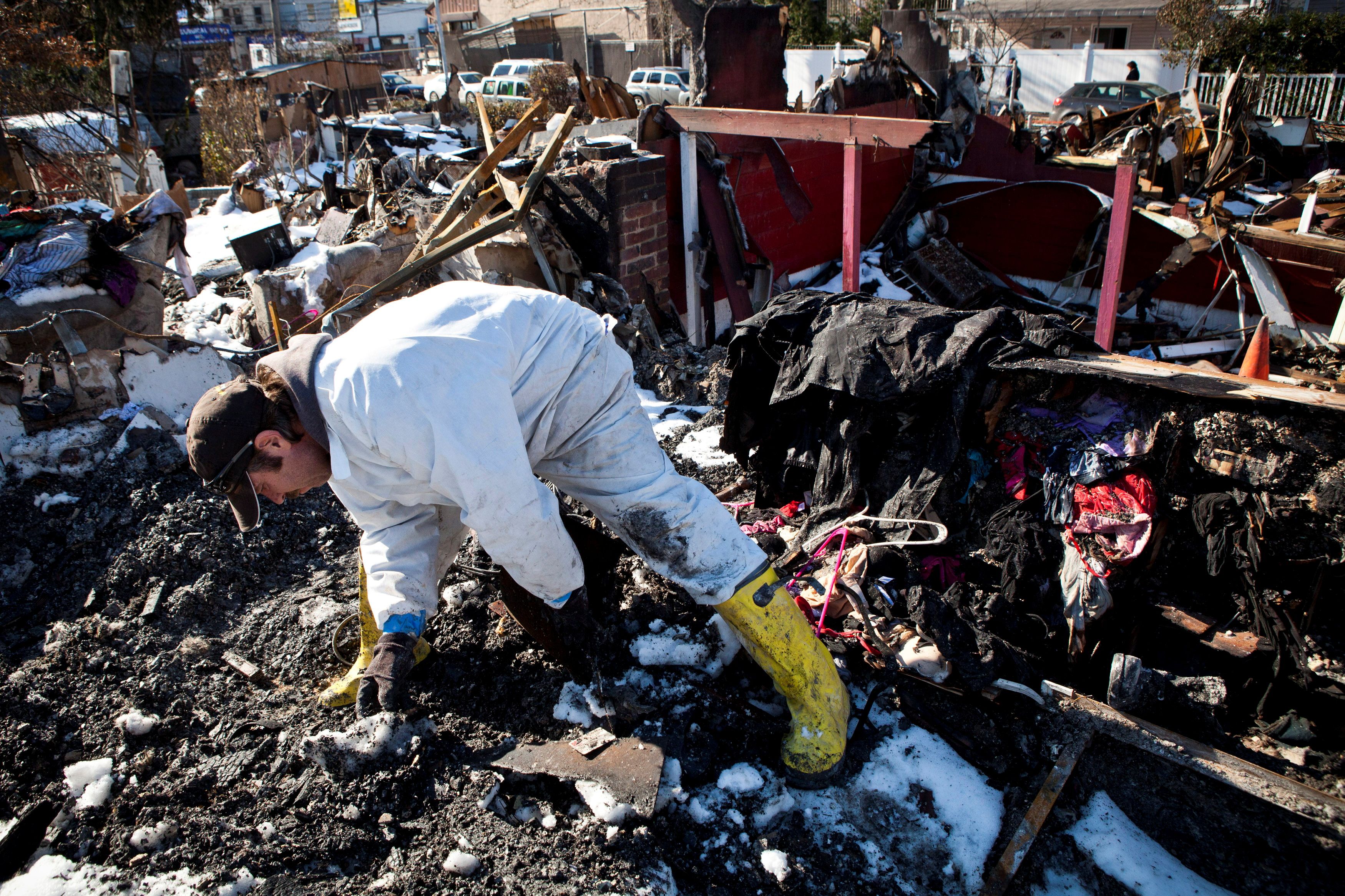Sylvester searches through remains of his house which was flooded and then burned to the ground during Hurricane Sandy for corpses of his five cats in Midland Beach neighborhood in Staten Island