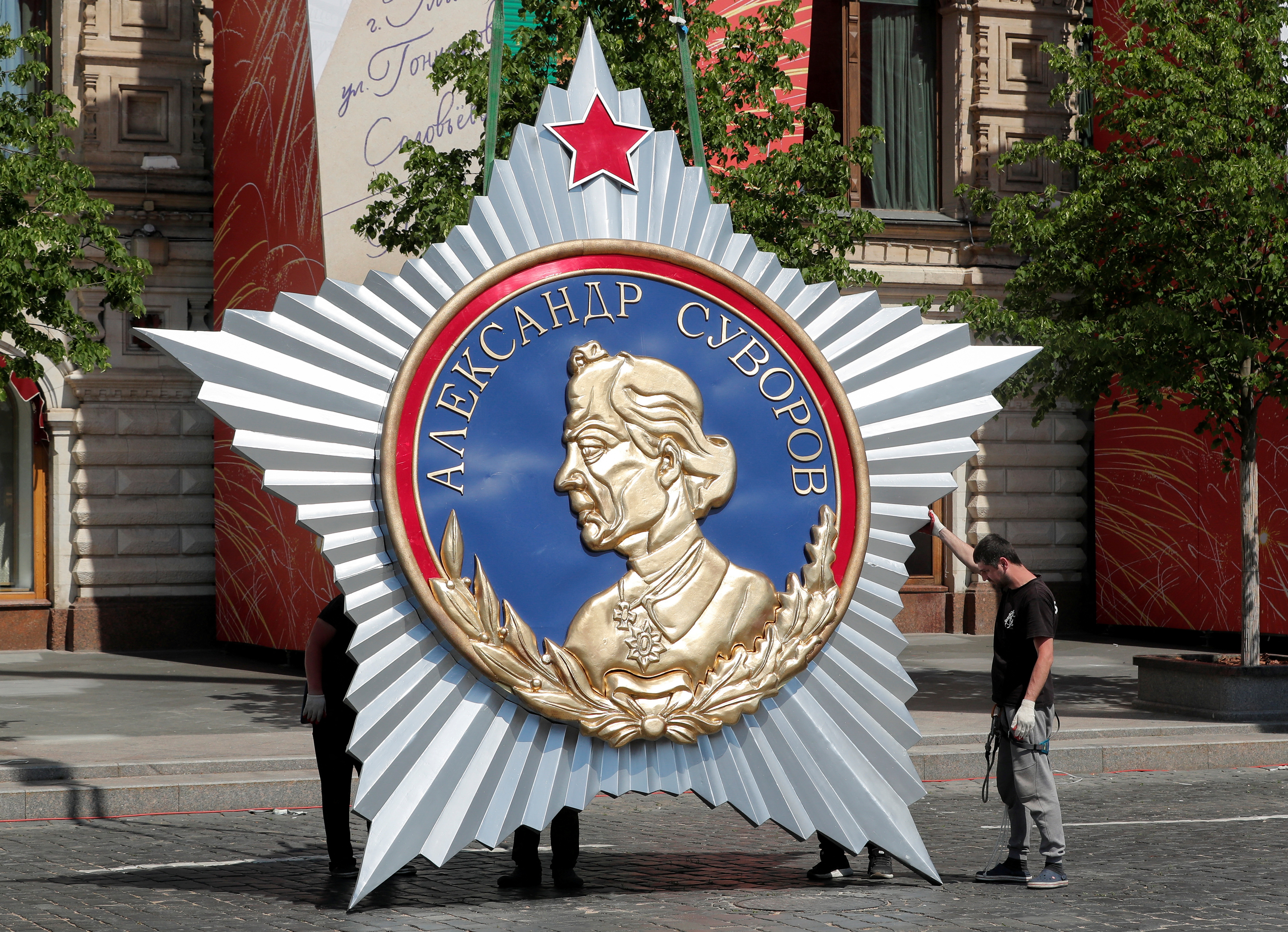 Workers set up a decoration during preparations for the Victory Day military parade in Moscow